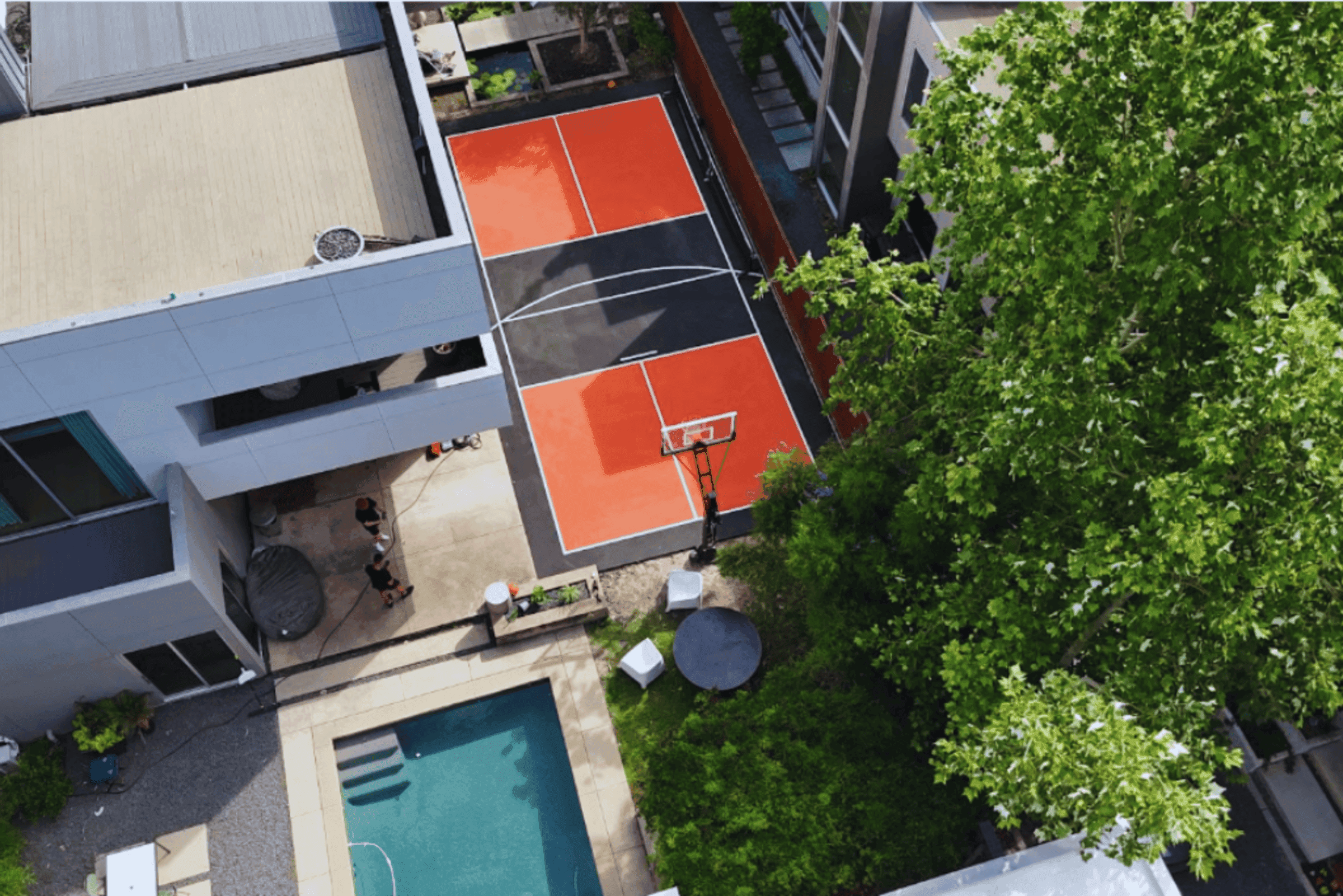 Rooftop pickleball and basketball court with custom red and black color scheme built by BuildMyCourts showing professional court construction in urban residential setting