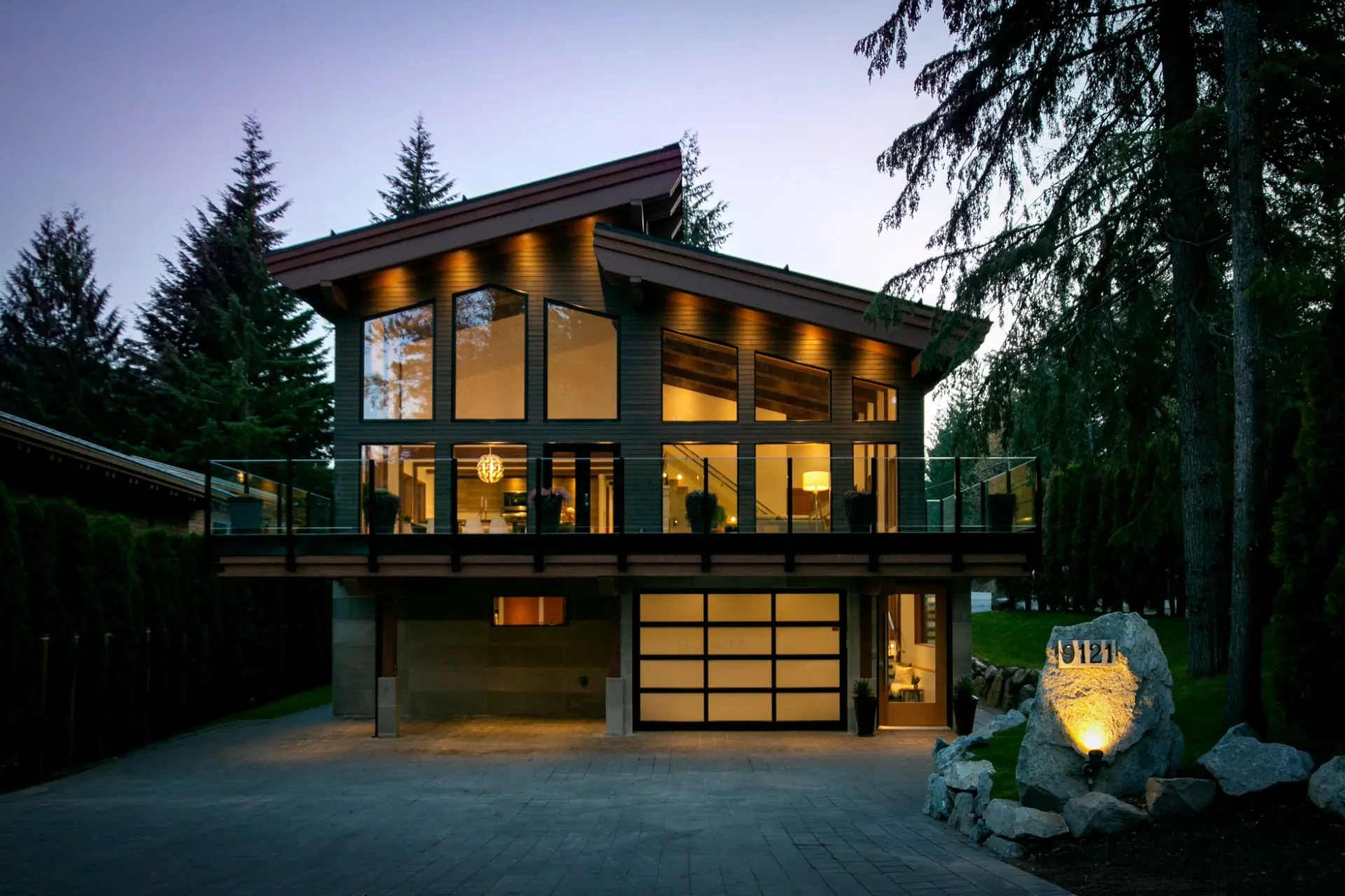 Summer Place custom home in Whistler lit up at dusk, showcasing the finished exterior.