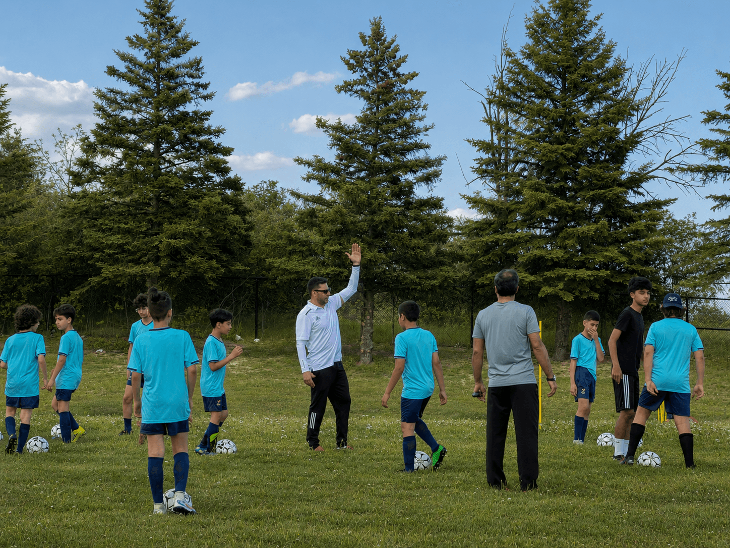 Hamed coaching youth soccer players outdoors