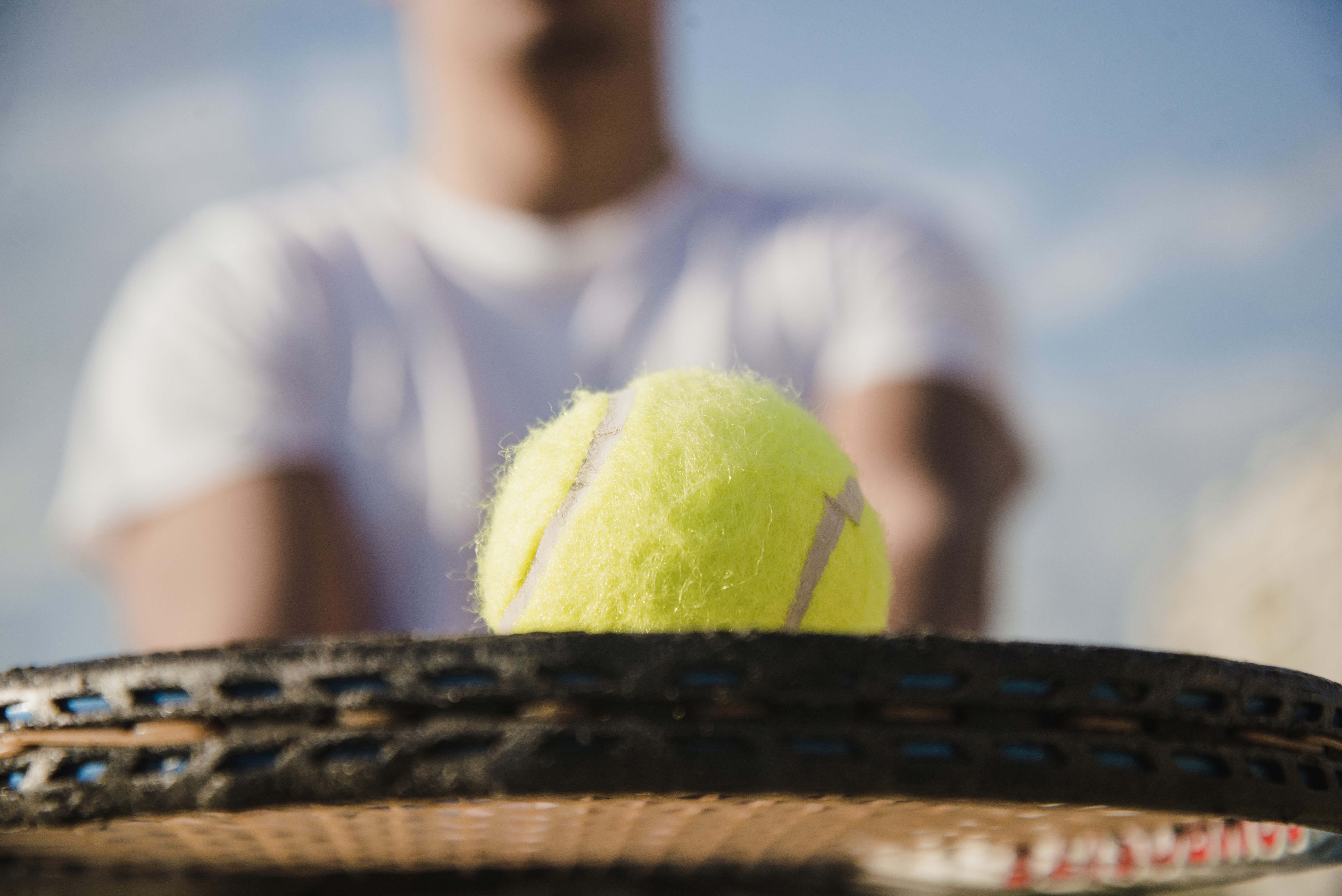Close shoot of  a tennis ball above a raquet