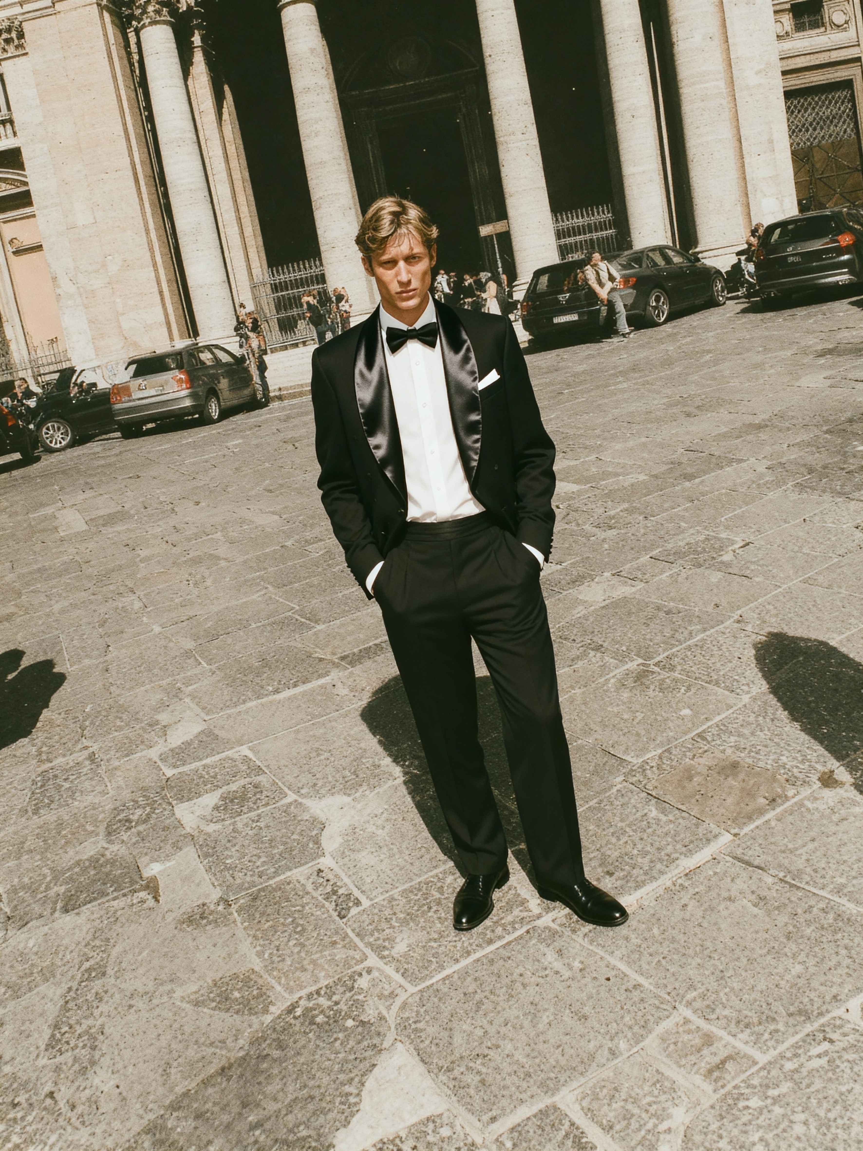 AI fashion visual of a man in a black tuxedo standing confidently in a European plaza, produced by Myrovia Labs for Forzieri. AI campaign photography for luxury menswear brands.