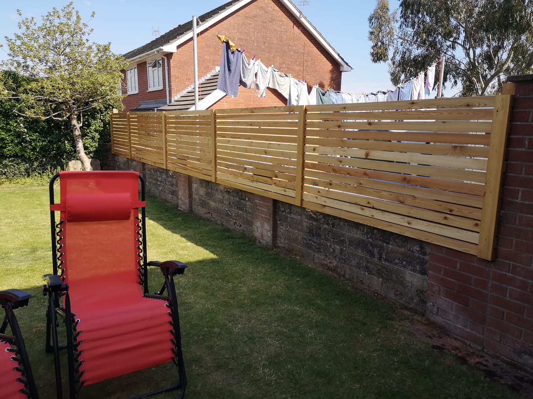 Horizontal slatted fence set on an existing wall