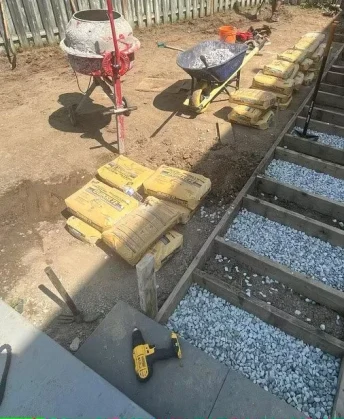 “Construction materials and gravel base ready for concrete service by Falcons Landscaping.”