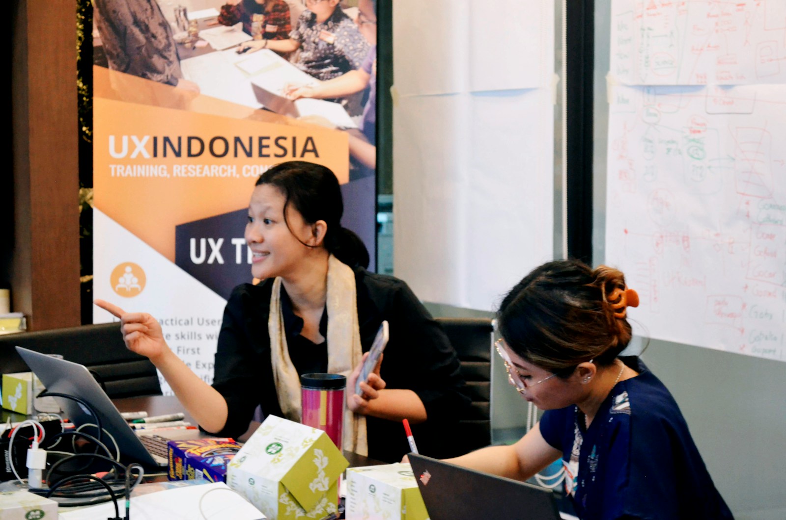 Indonesian web and design team working on laptops in an office