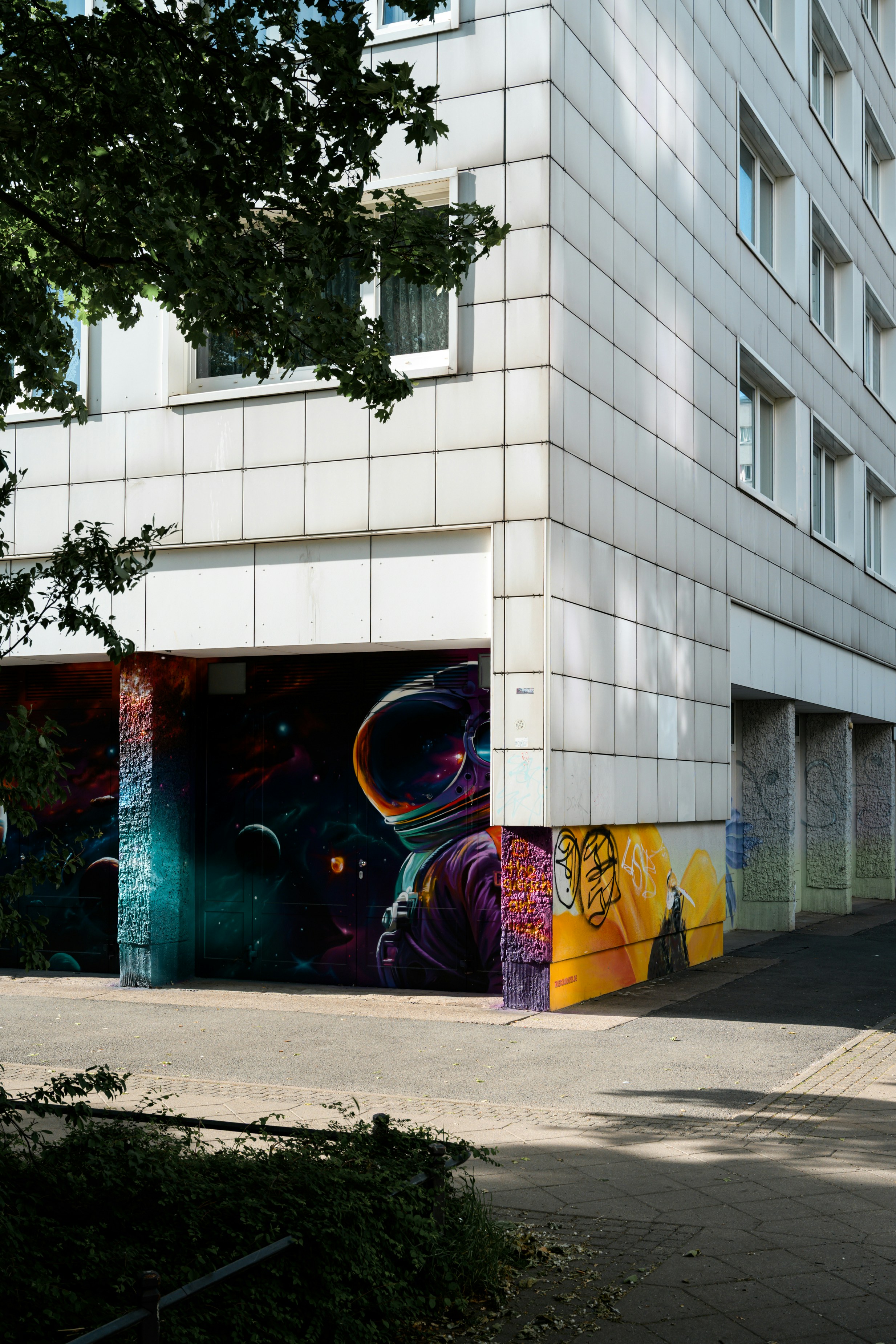 Colorful astronaut mural on a modern building's facade.