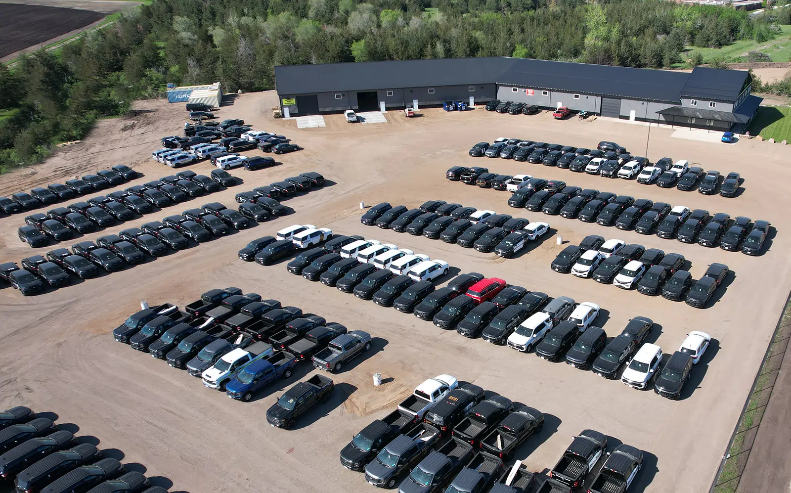 Aerial view of the Guardian Fleet Safety facility with dozens of vehicles parked in rows outside the build shop