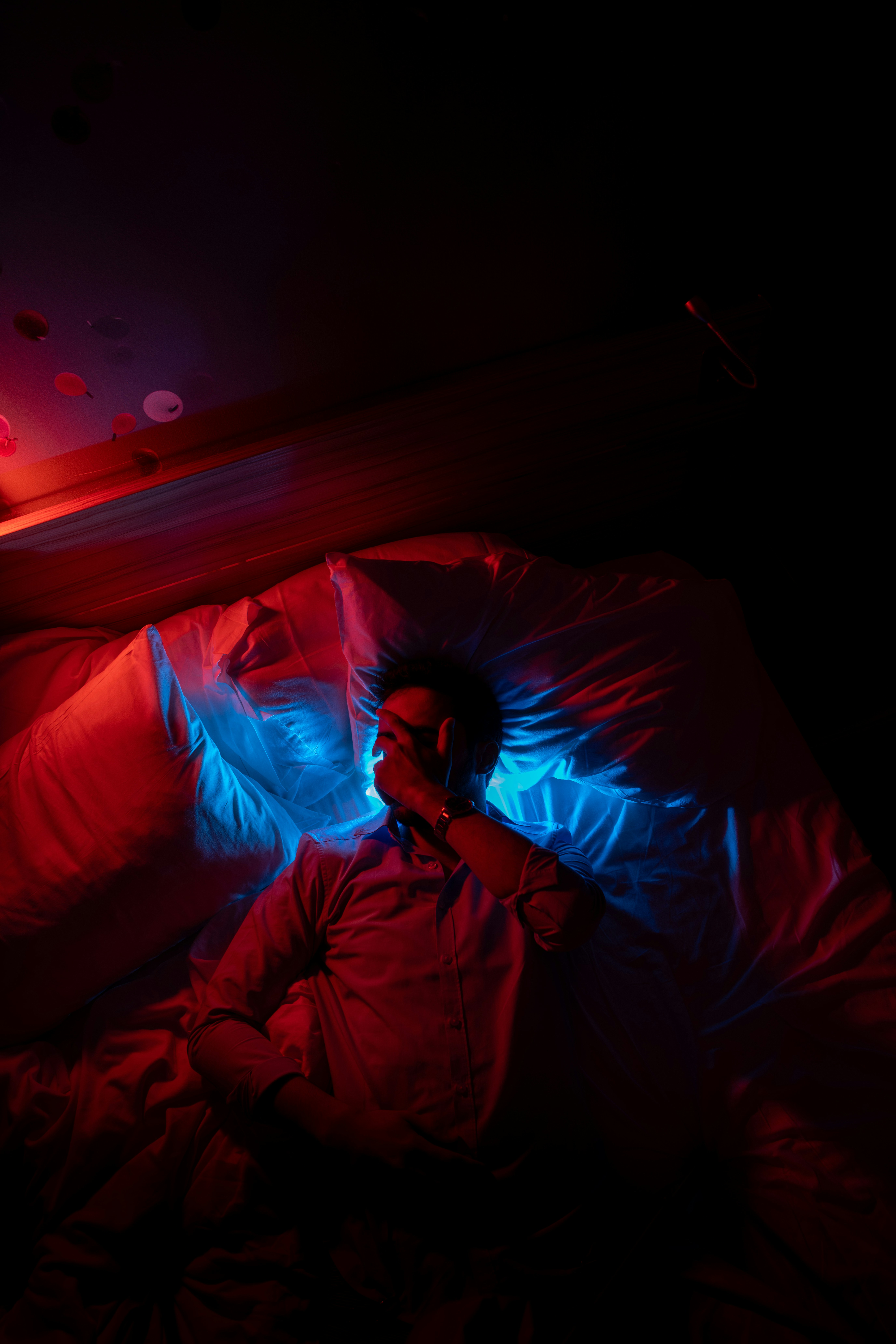 A person laying in a bed in a dark room