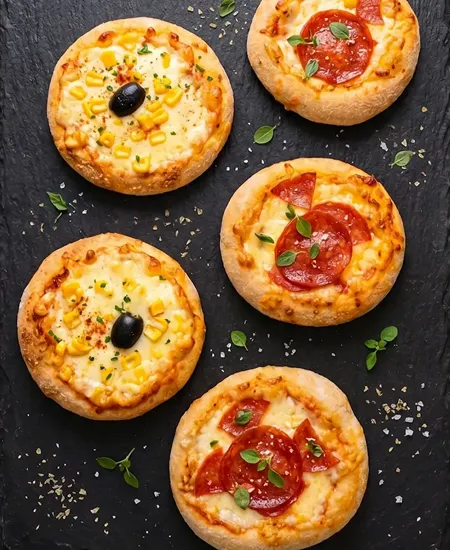 Pizzetas gourmet de pepperoni y choclo en base de pizarra para cumpleaños y eventos en Providencia.