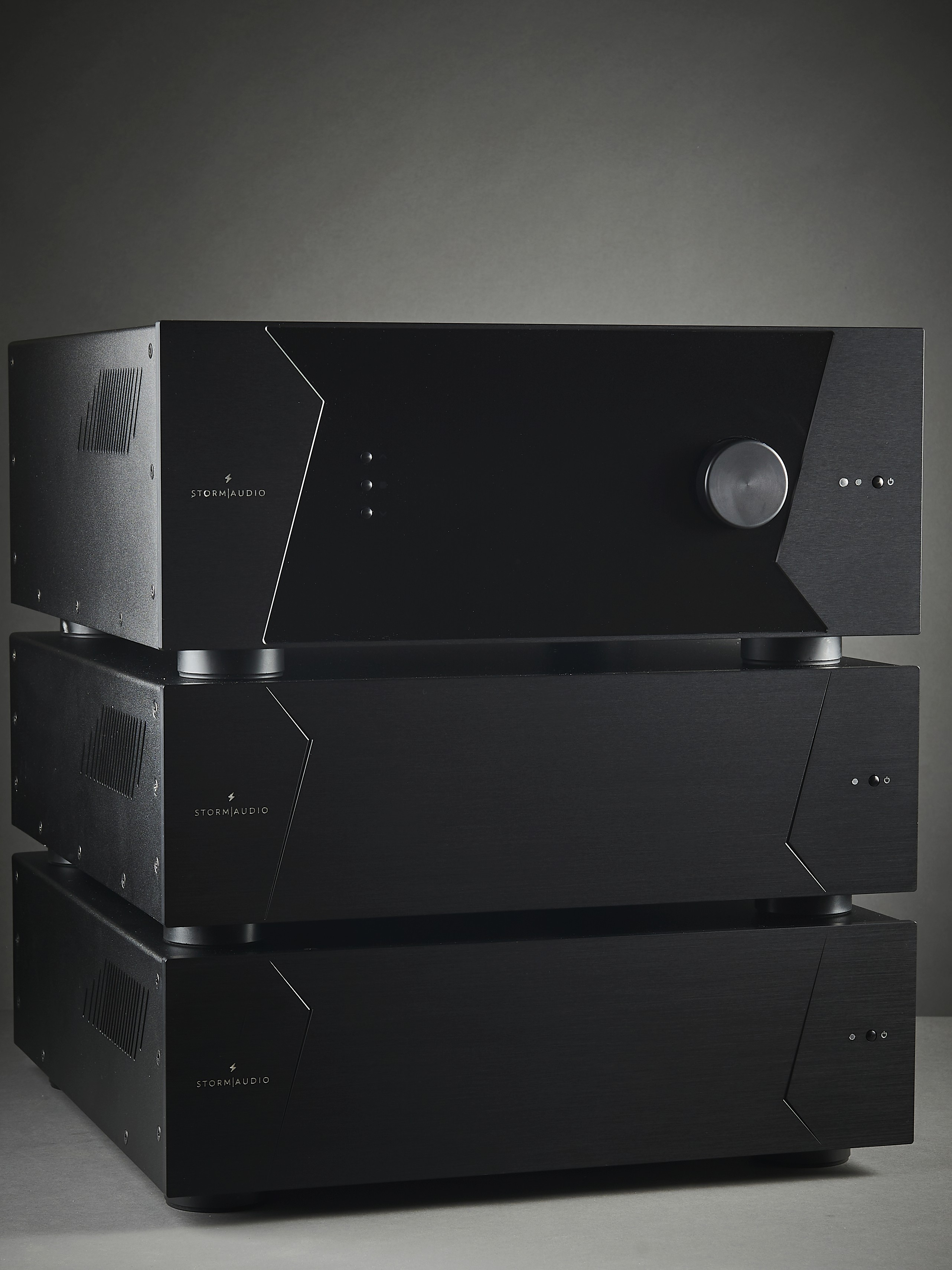Three black audio amplifiers stacked.