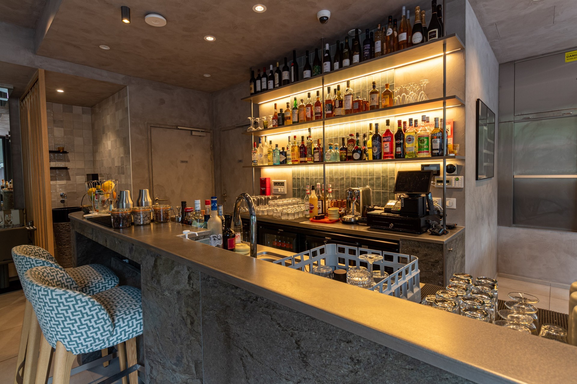 Modern house with clean lines, white and red stone walls, glass entrance, and desert landscaping under a clear blue sky.