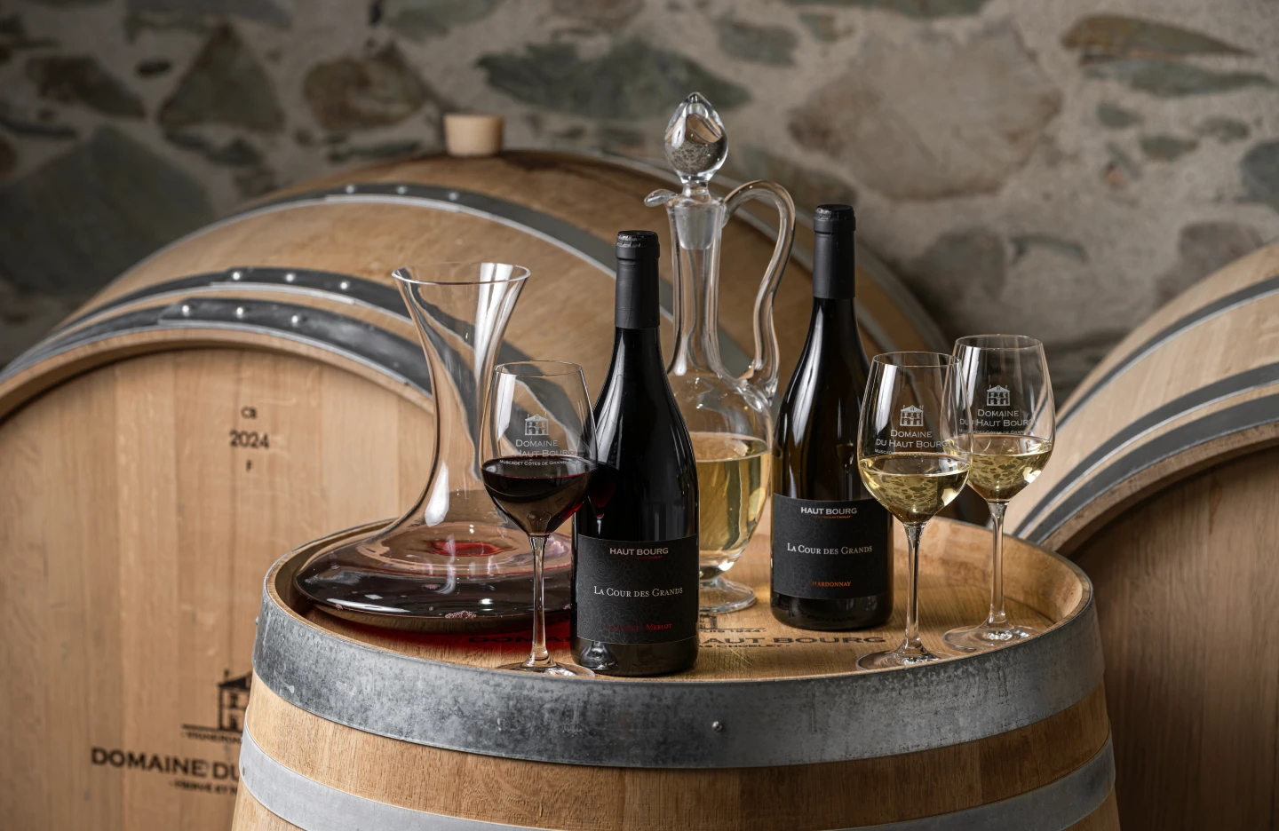 Bouteilles de La Cour des Grands et carafe sur un fût de chêne