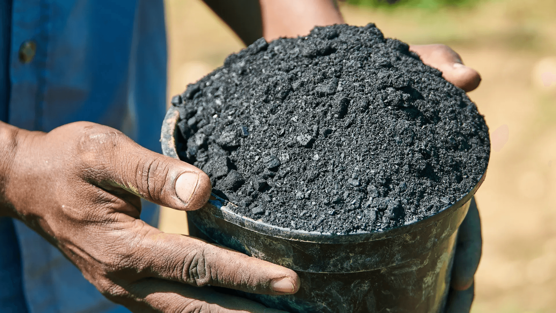 two hands holding biochar for carbon removal
