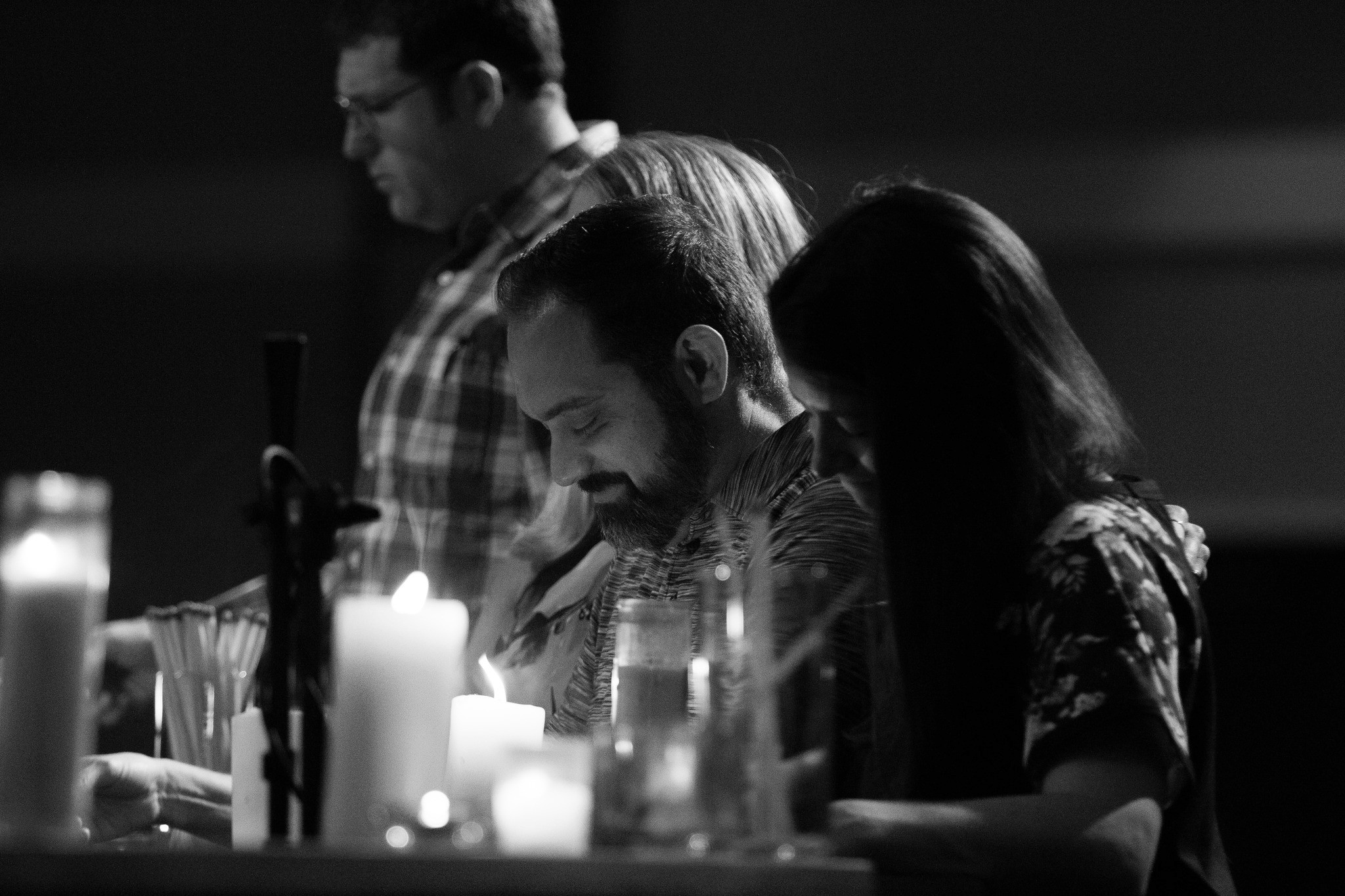 People praying by the altar lit by candles