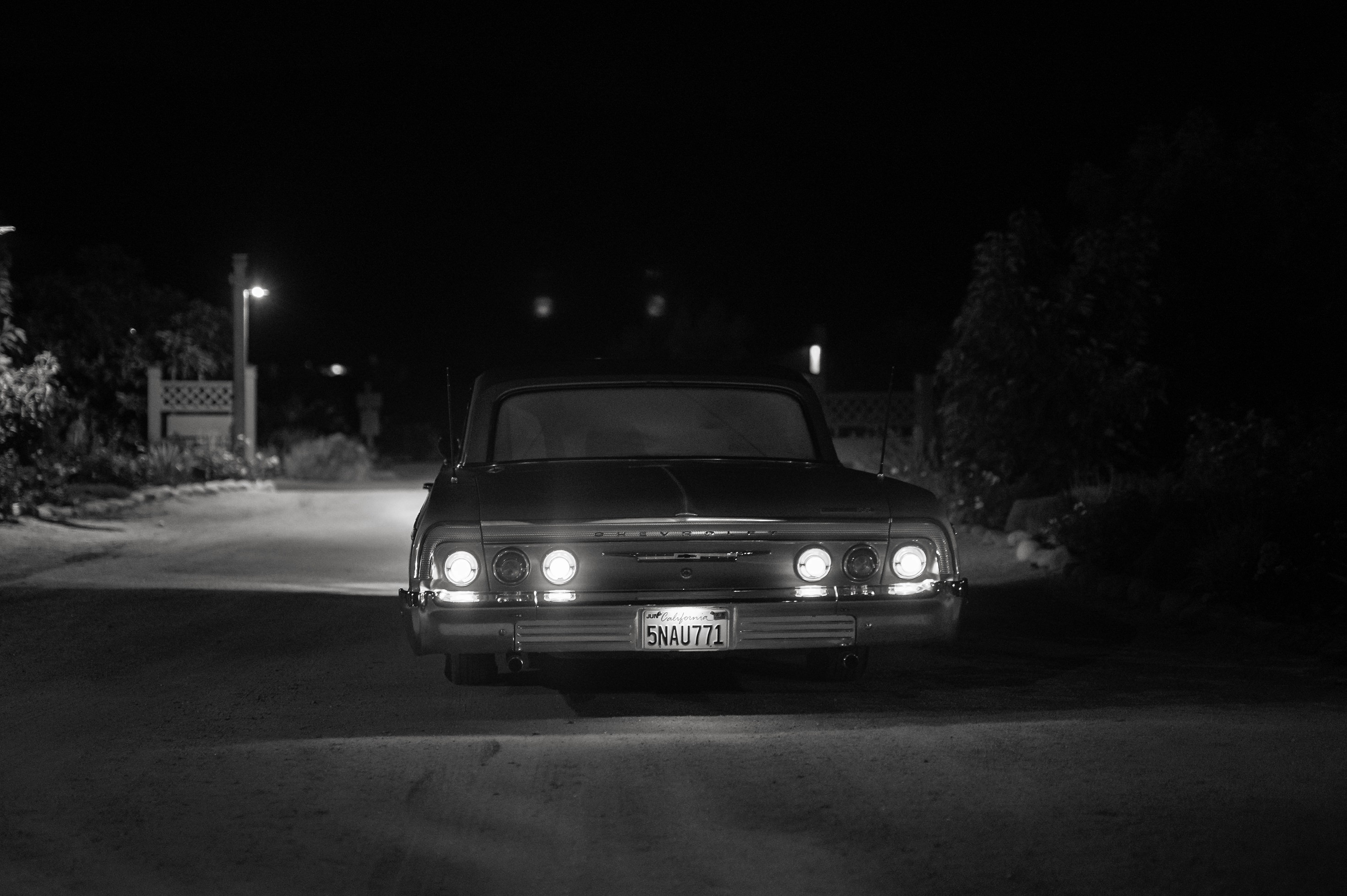 Classic car driving away at night wedding exit photo