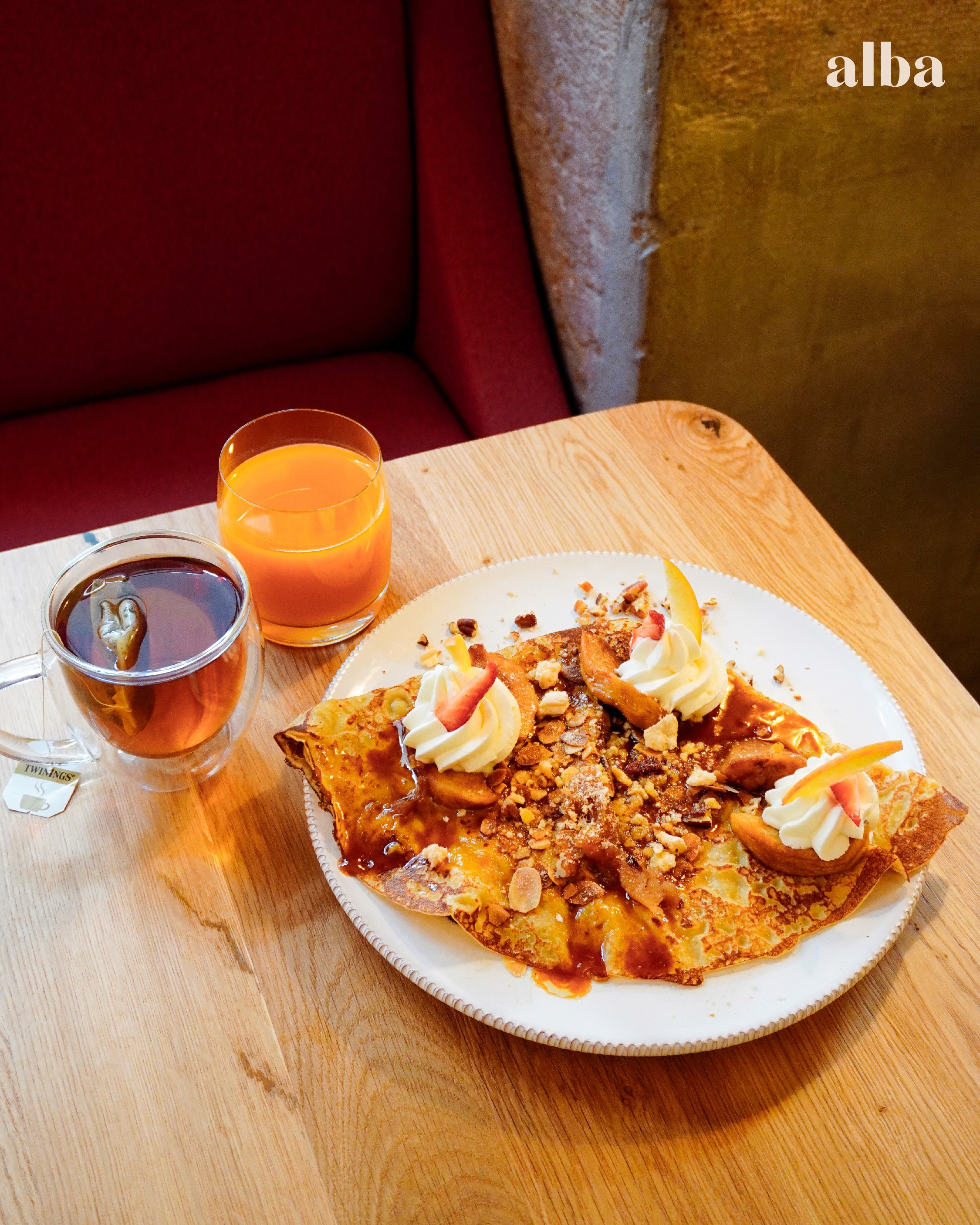 a glass of cocktail with a slime orange fruit