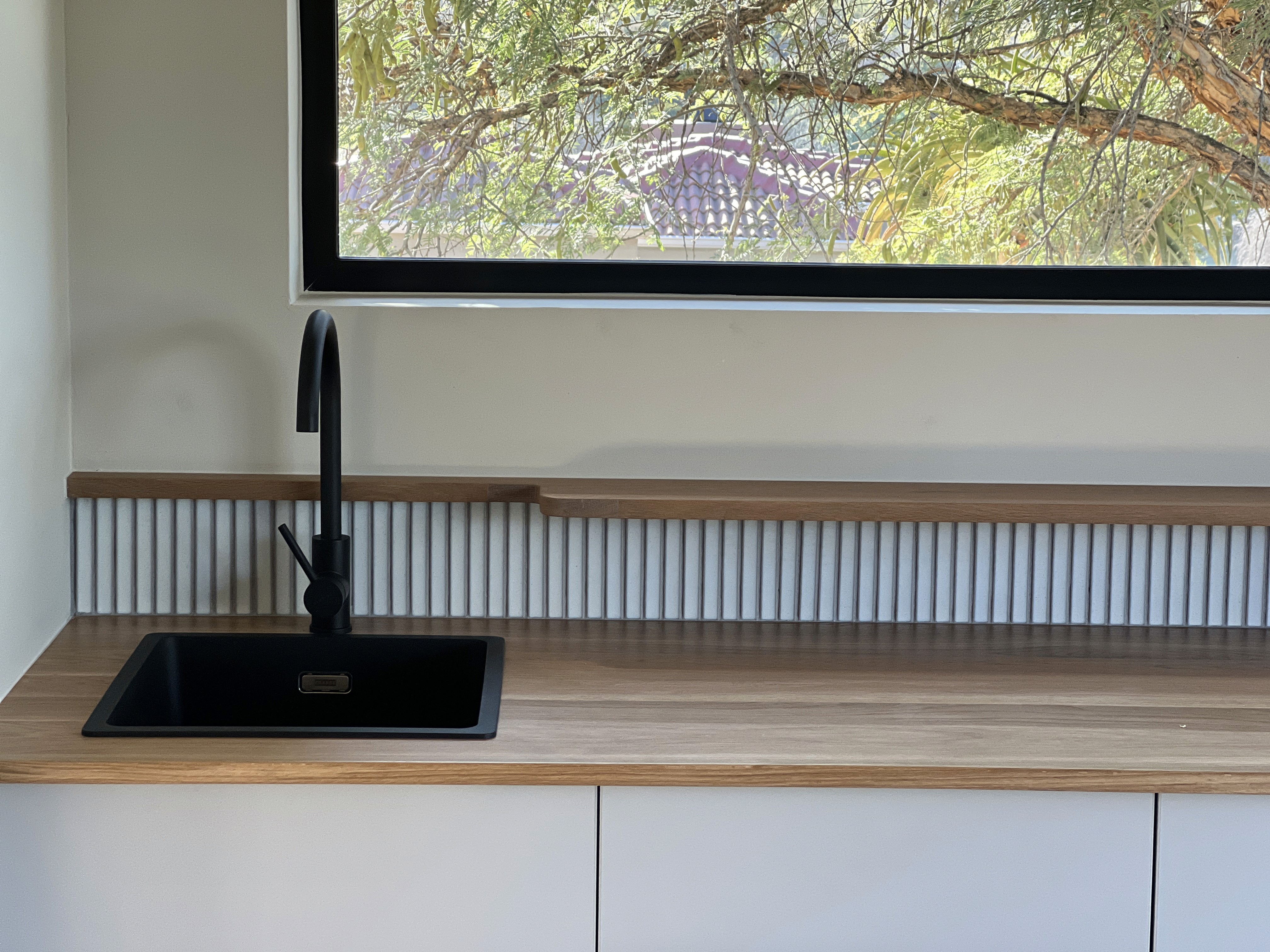 Modern interior entrance with floor-to-ceiling glass walls and warm timber cladding overlooking landscape