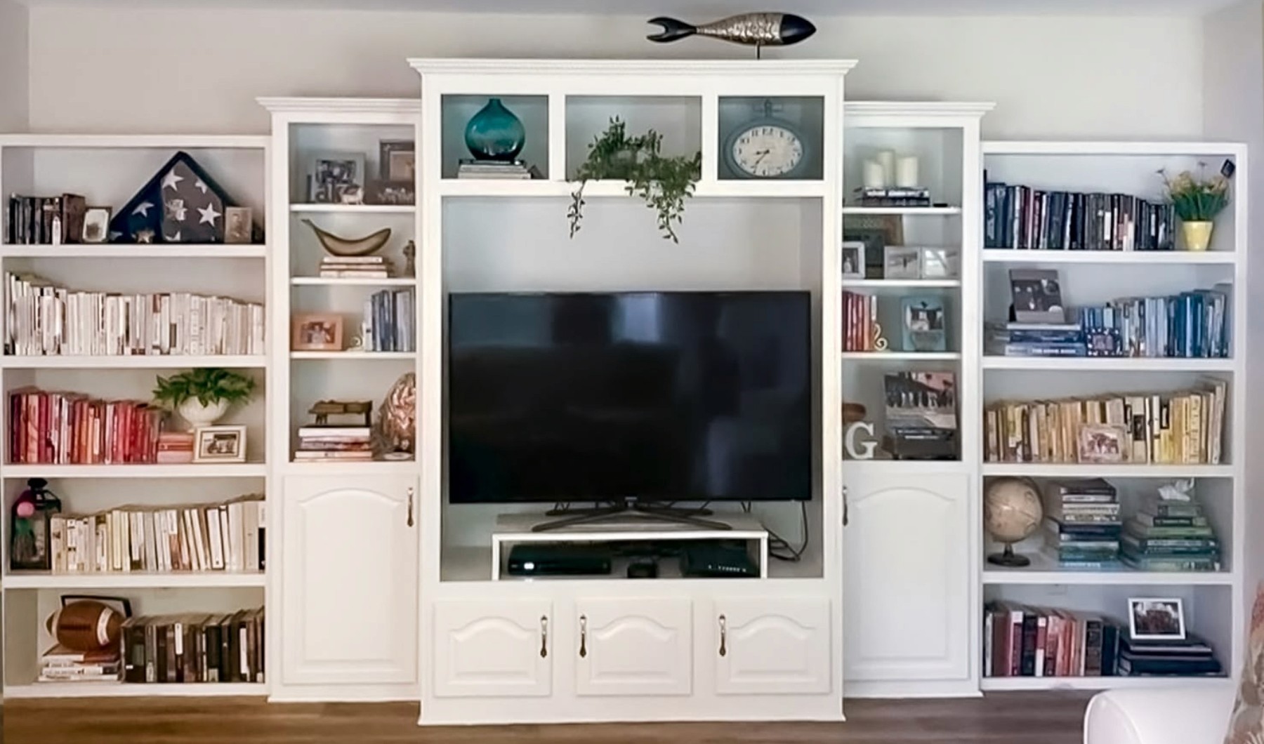 white modern bookcase built in with books and styled decor