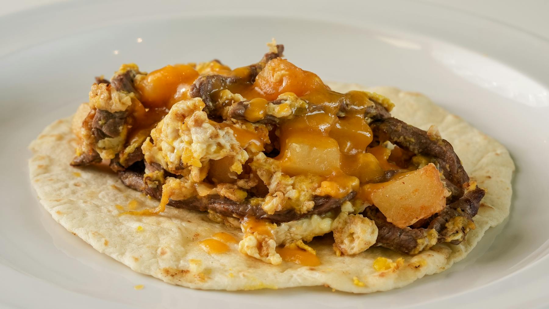 POWER TACO Tender steak, hearty potatoes, fluffy eggs, and melted cheese wrapped in a soft tortilla