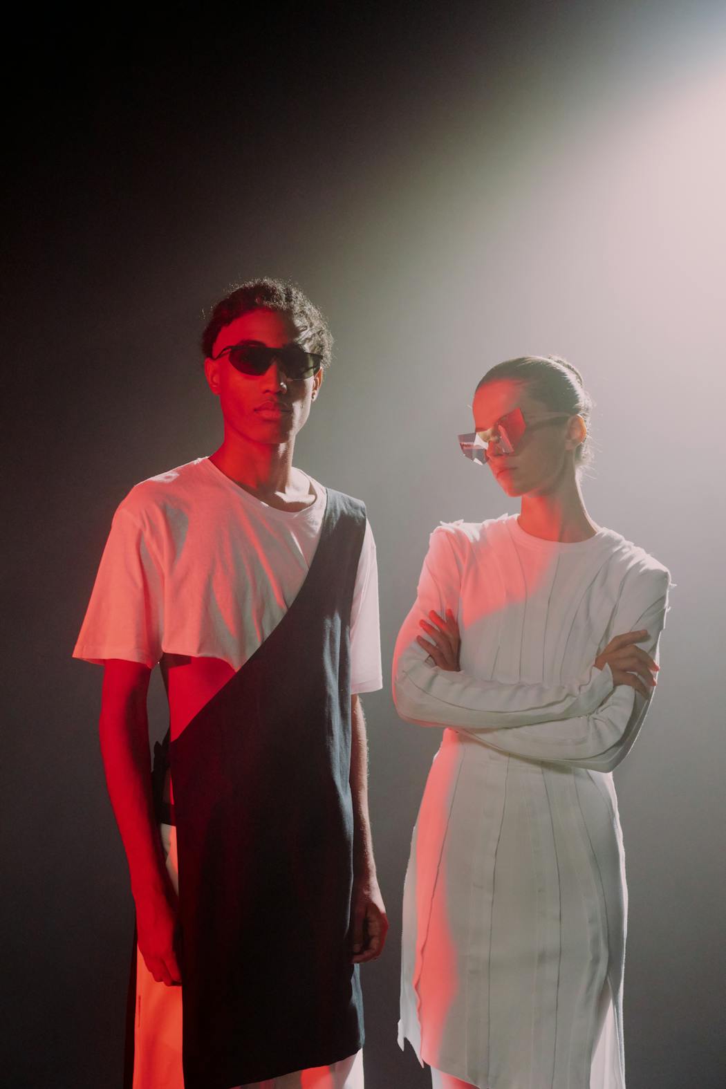 Man and women in white outfits and large sunglasses