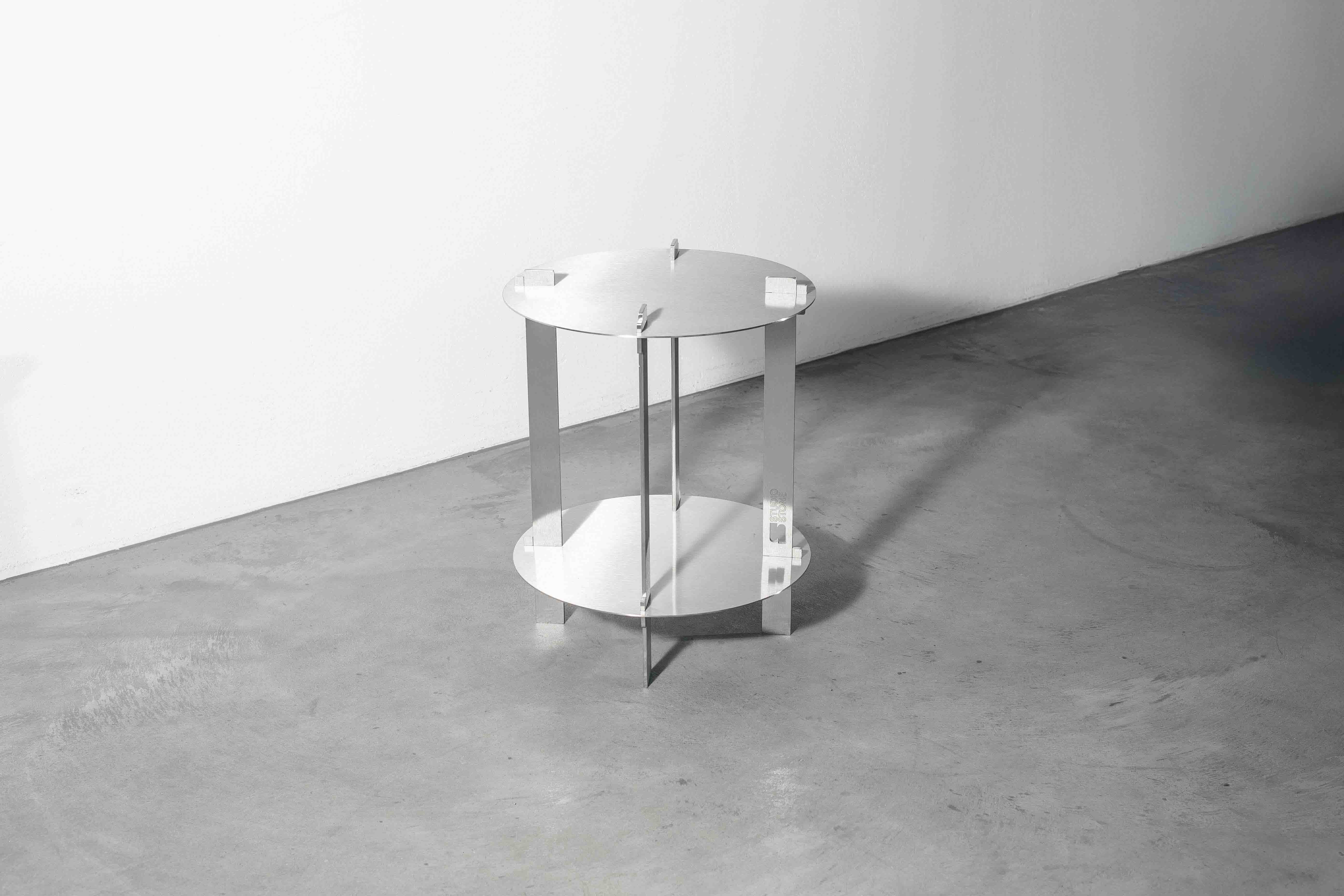 sideview of a metal designer table on a concrete floor