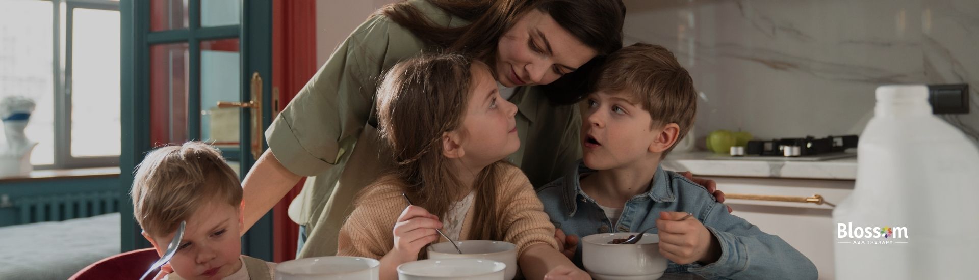 Three kids eating with their mother.