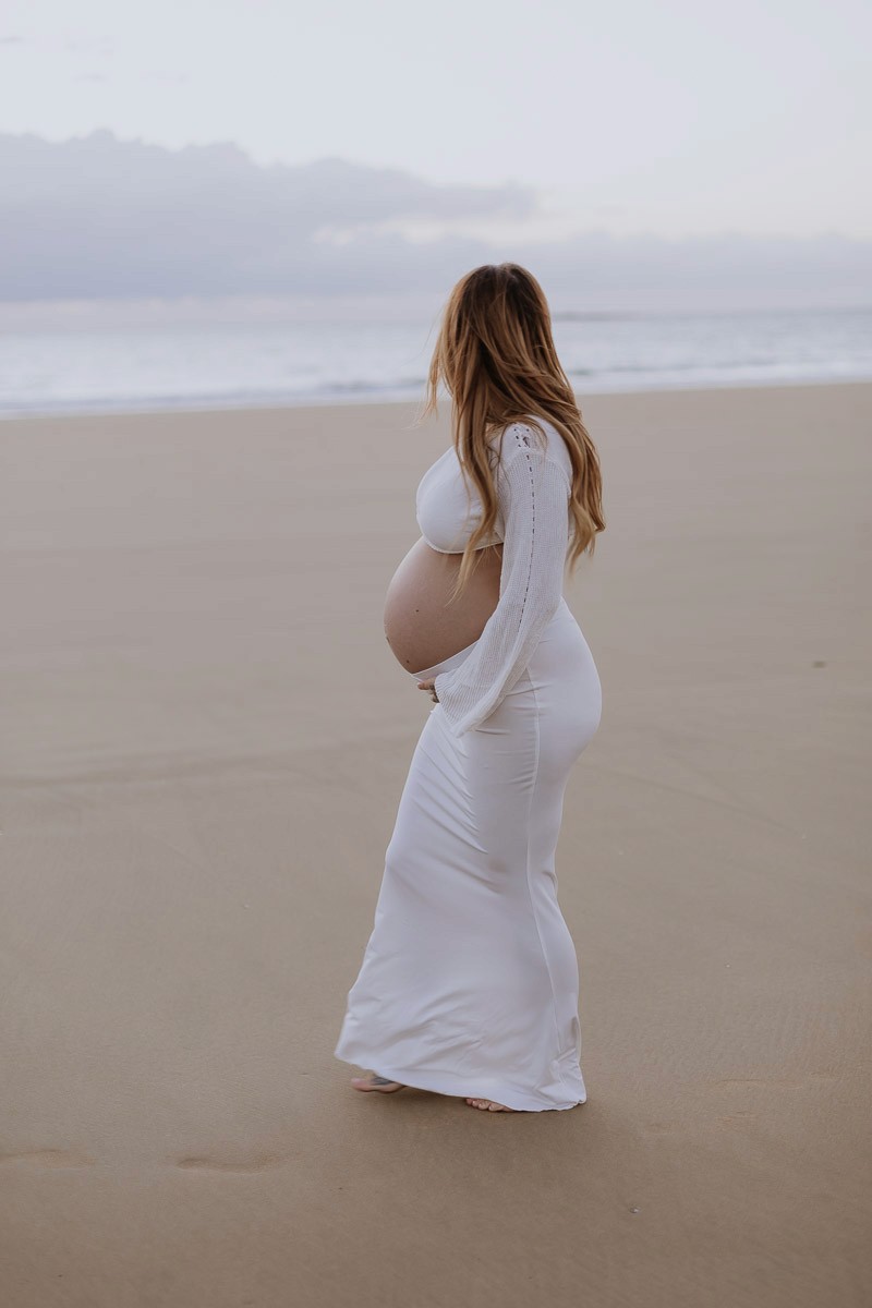 Beach maternity photo of an expectant mother with ocean backdrop