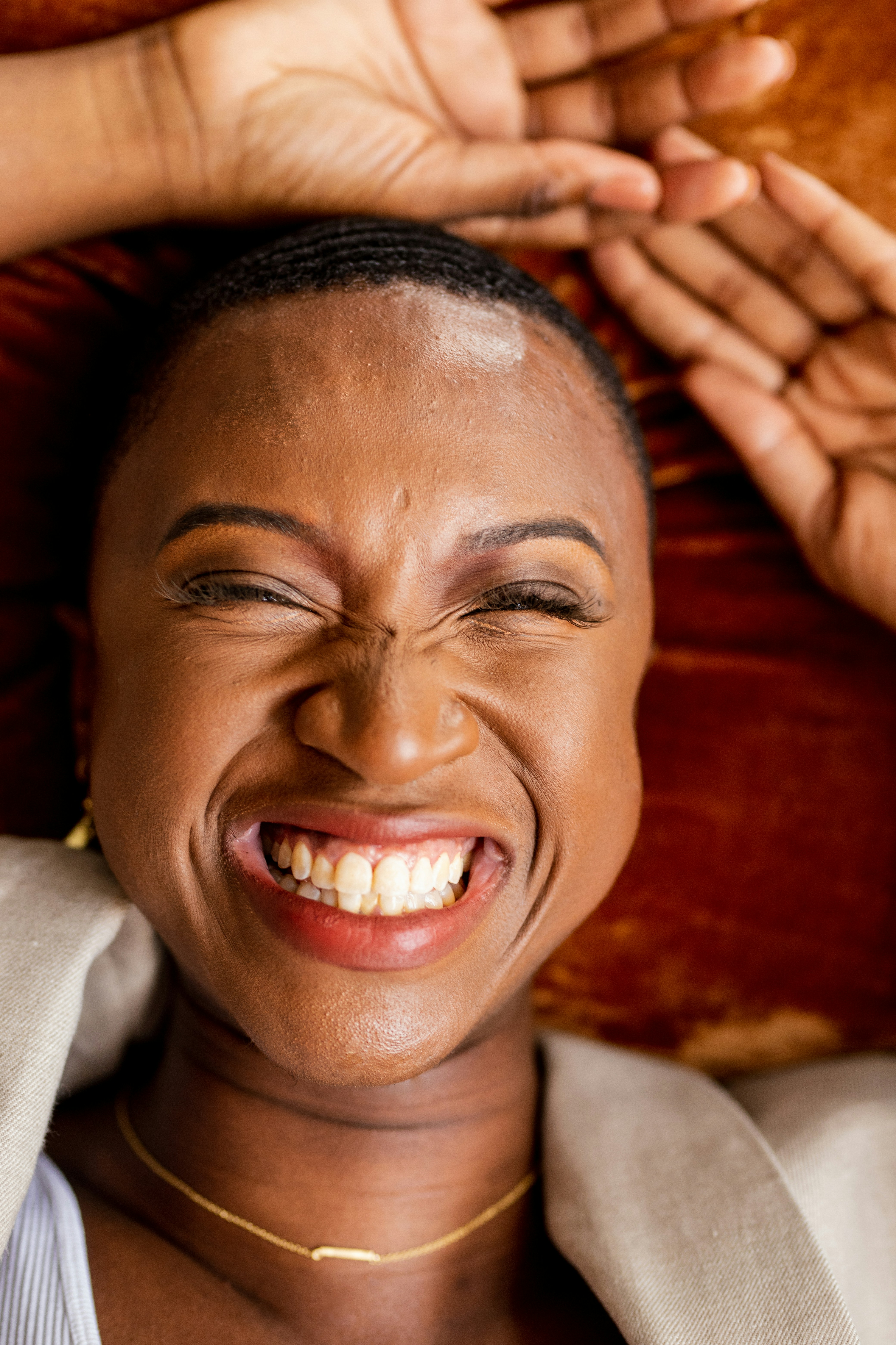A woman smiling with her hands on her head