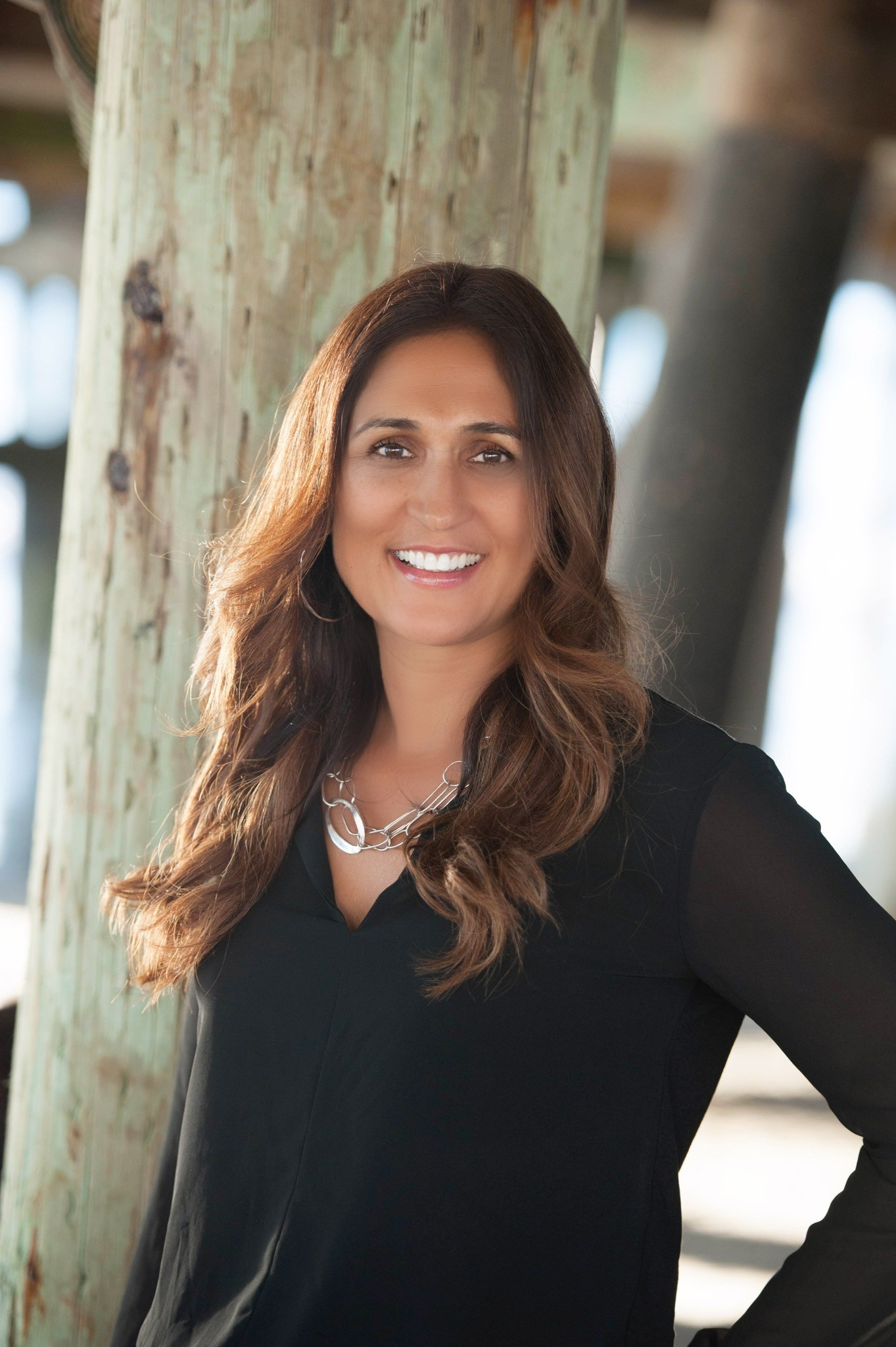 a woman wearing a white dress and gold hoop earrings