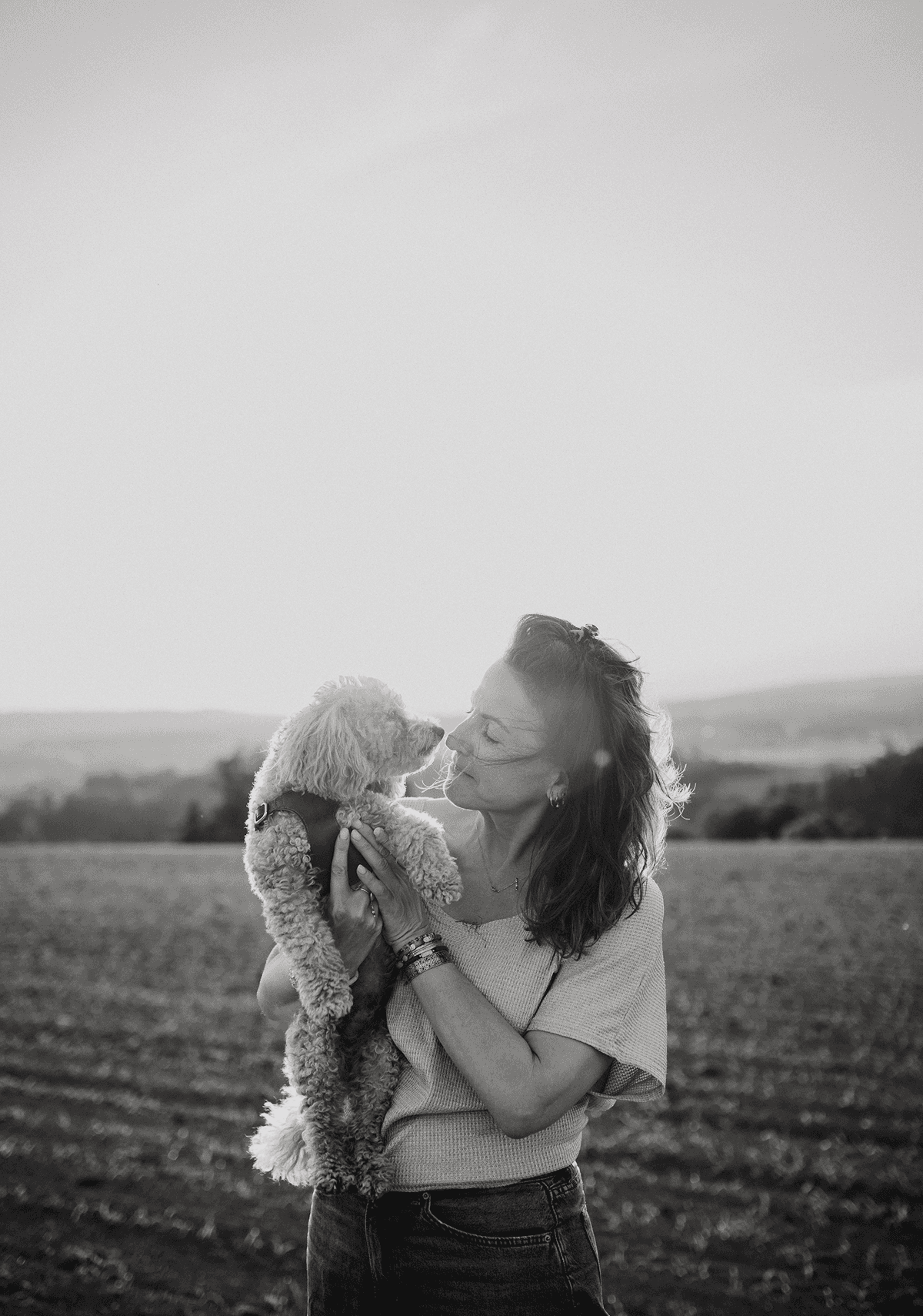 Black-and-white photo of a woman holding her child in a field