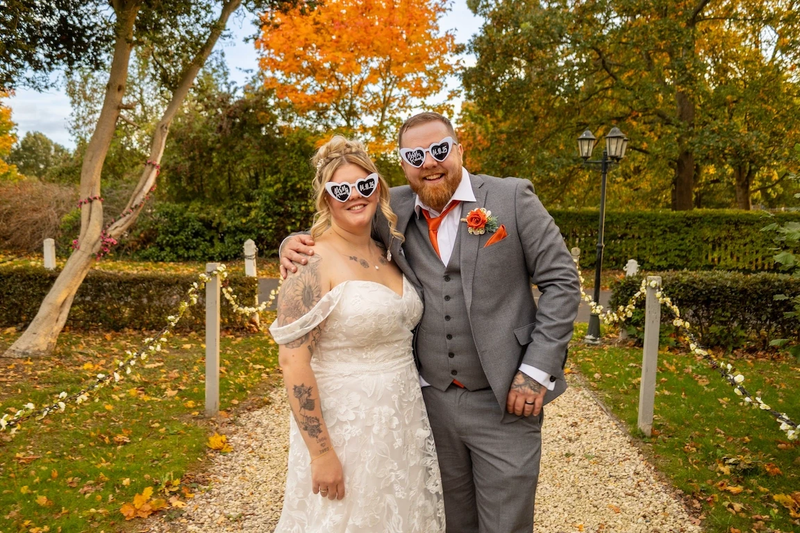 Bride and groom wearing novelty glasses during a fun autumn wedding portrait outdoors