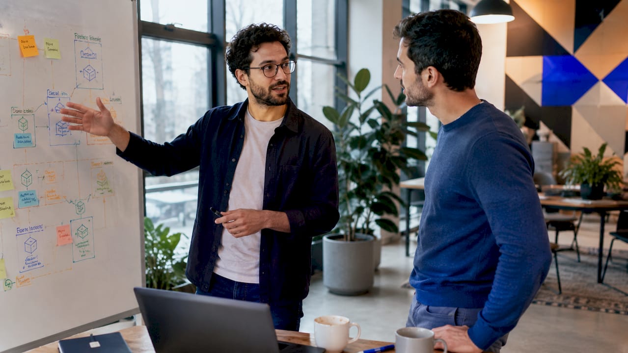 Two engineers discussing microservices in office