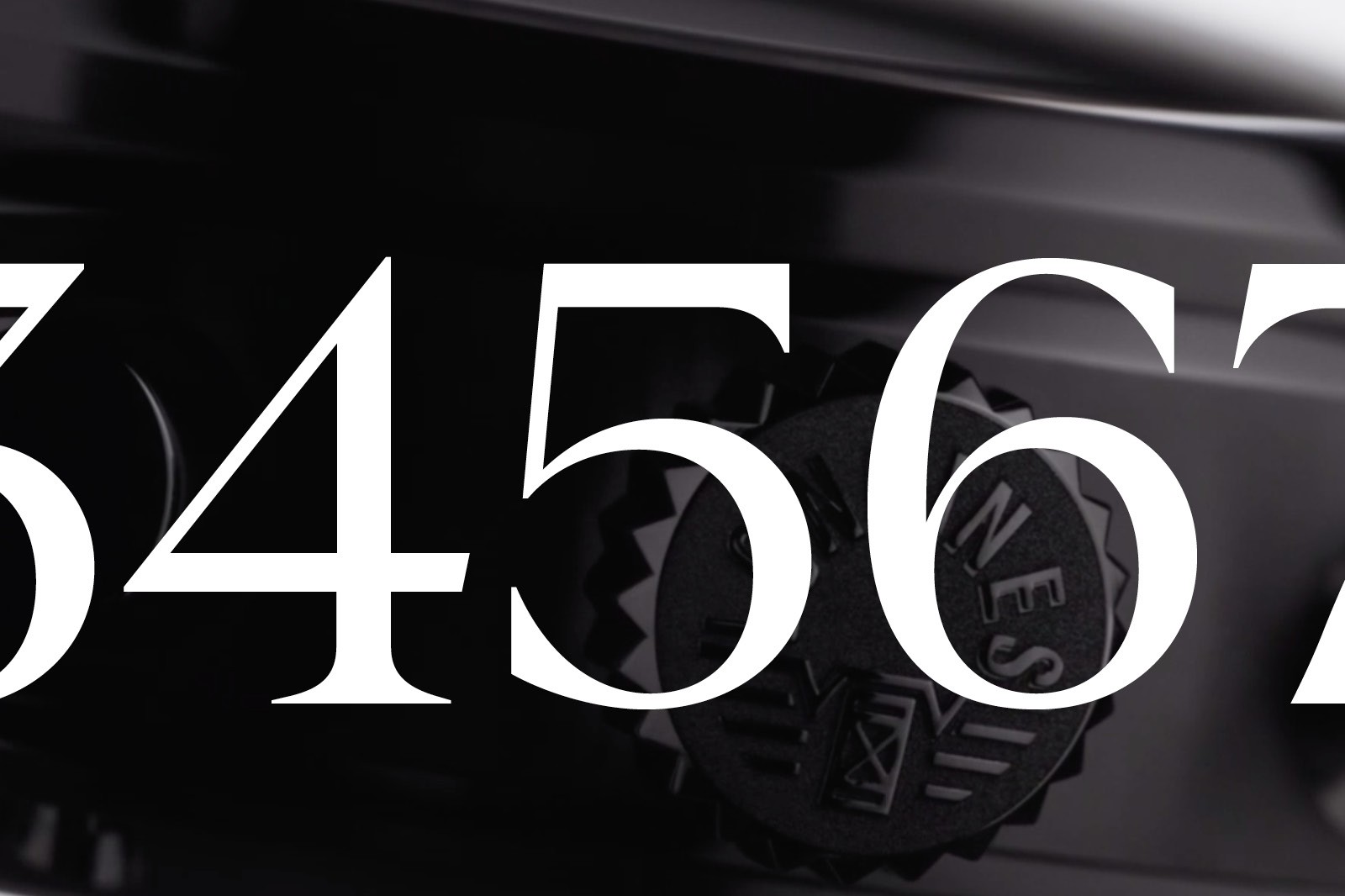 Close-up of a black surface displaying white numerals "34567" prominently.