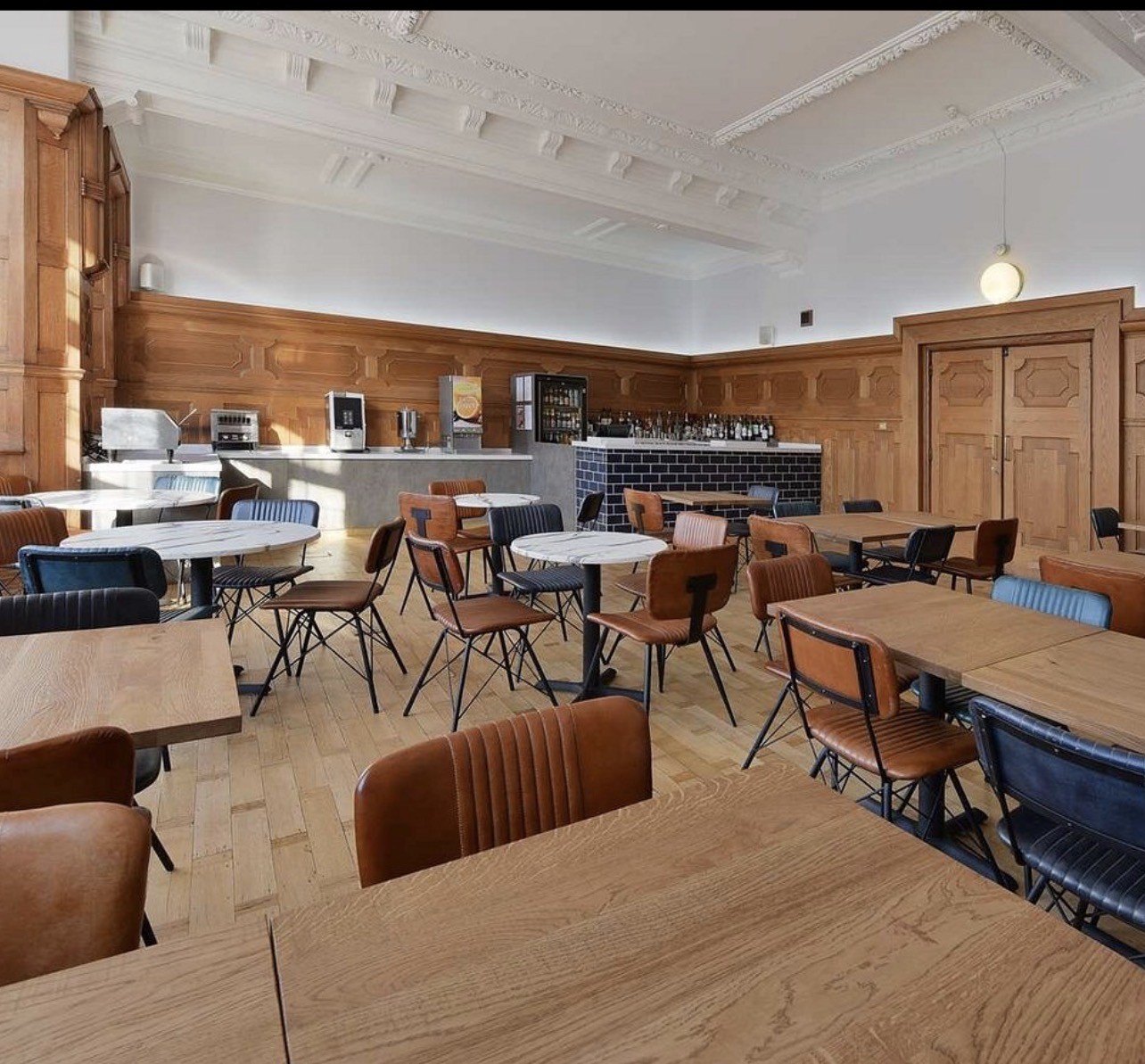 Aerial view of a winding road surrounded by dense green and yellow trees, showcasing nature’s vibrant colors.