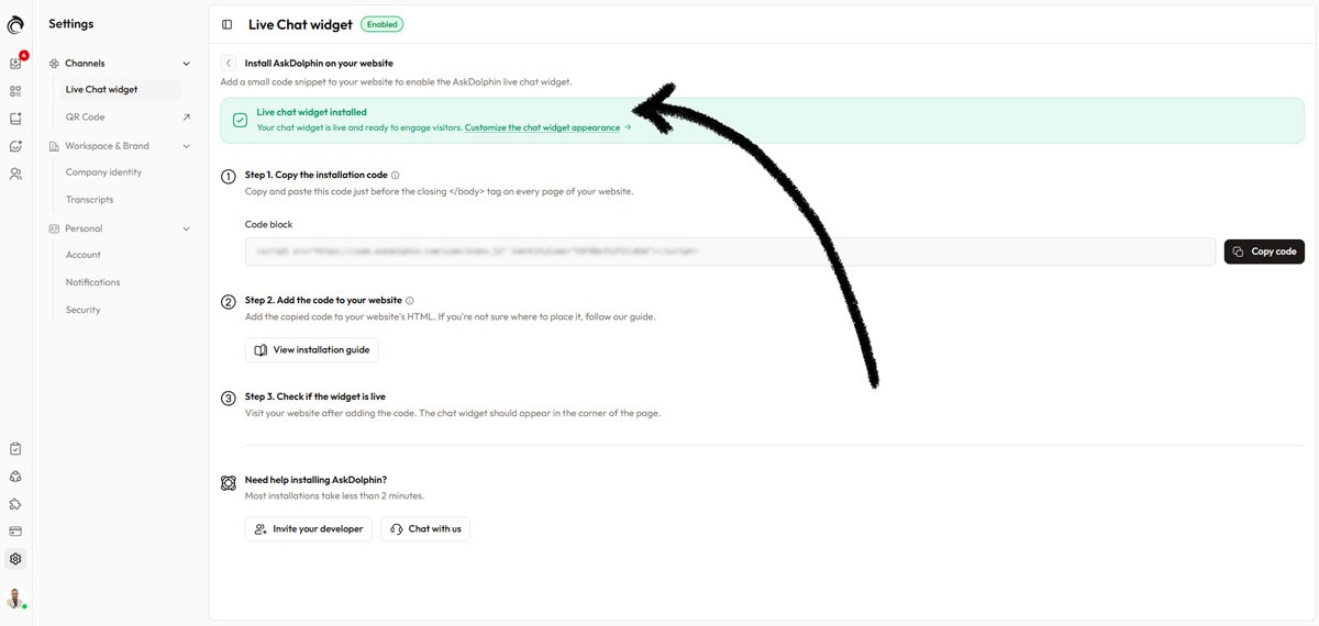 AskDolphin installation screen showing a green ‘Live chat widget installed’ status with an arrow pointing to the confirmation message.