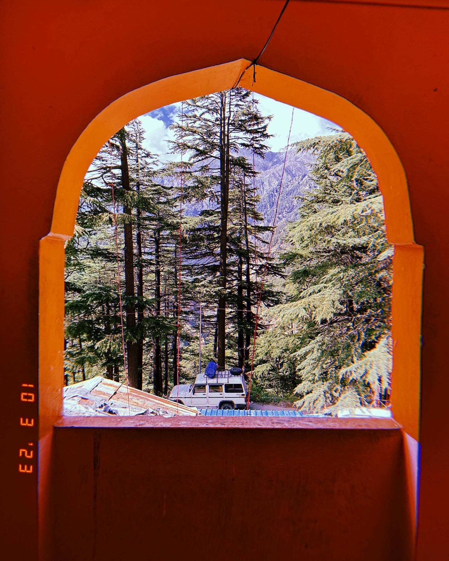 Mountain trees framed by an orange arched window