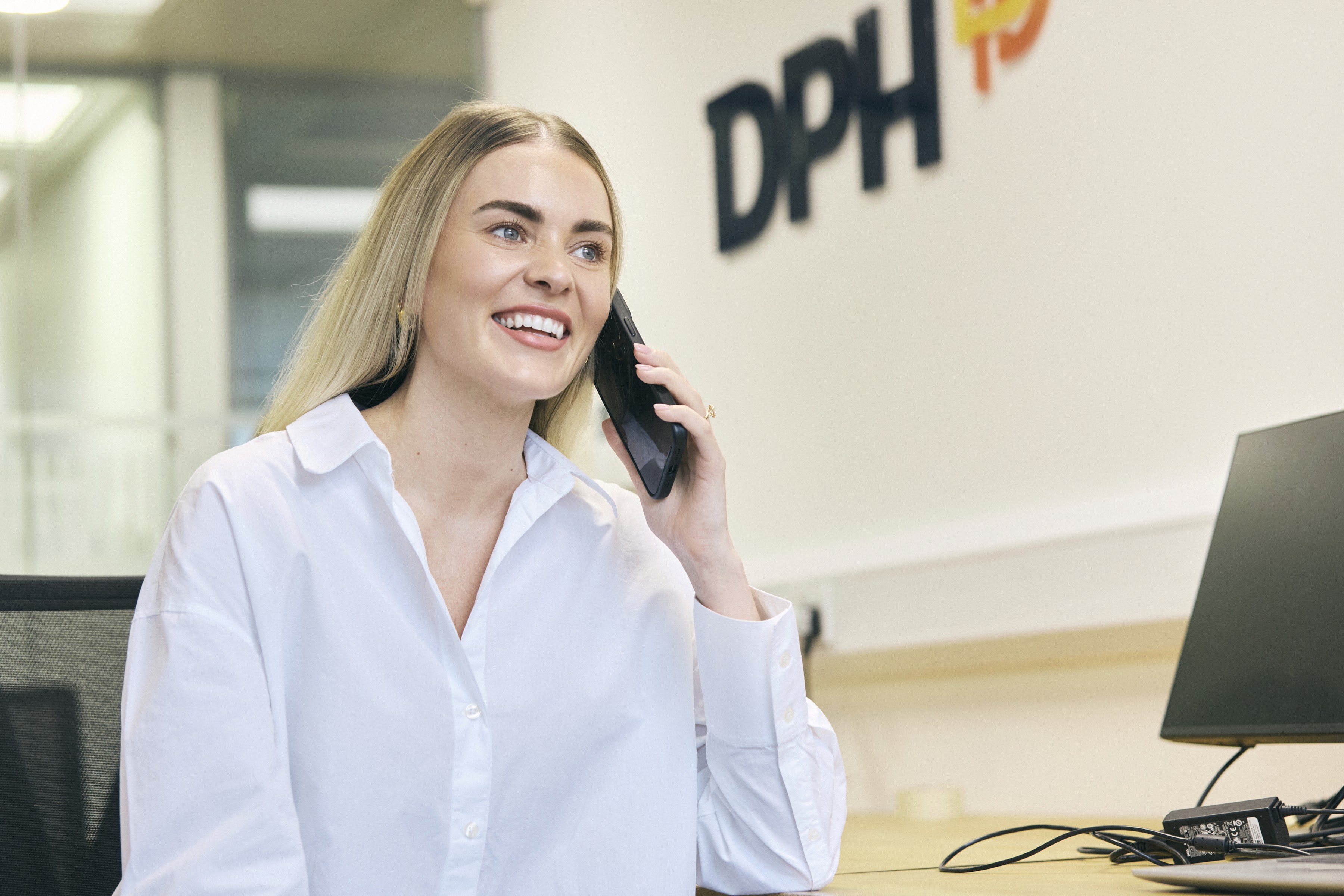 Rooftop garden with trees and plants, overlooking a cityscape at sunset with a tall building in the background