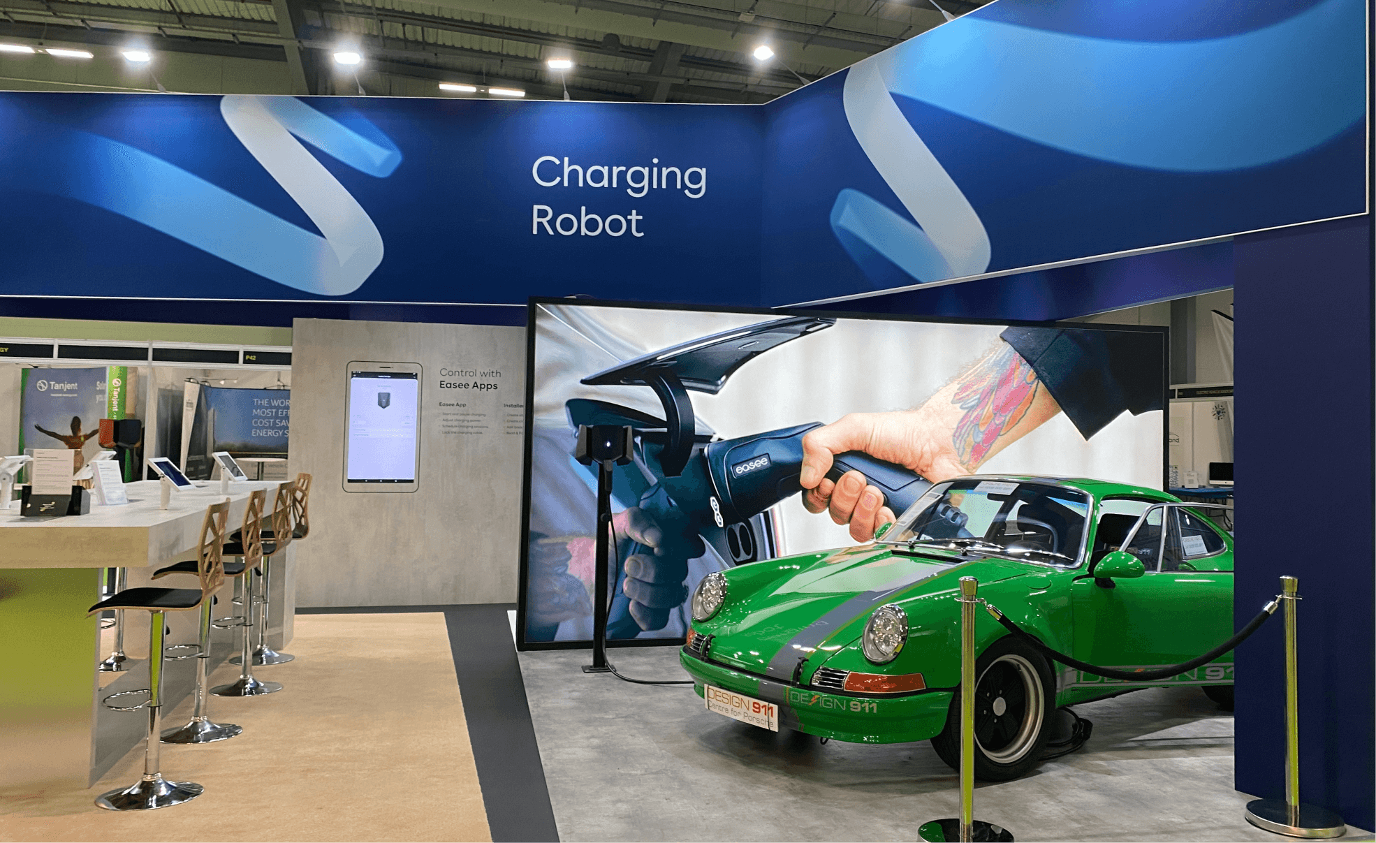 Modern home office setup with a monitor, ergonomic chair, keyboard, and indoor plants near a window with blinds.