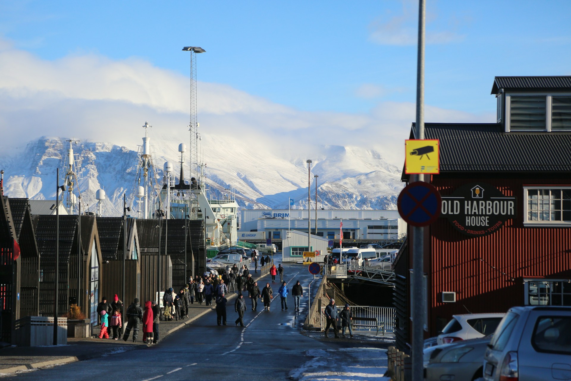 Reykjavik Old Harbor in winter with fishing boats, visitors, and Mount Esja covered in snow in the background.&nbsp;
