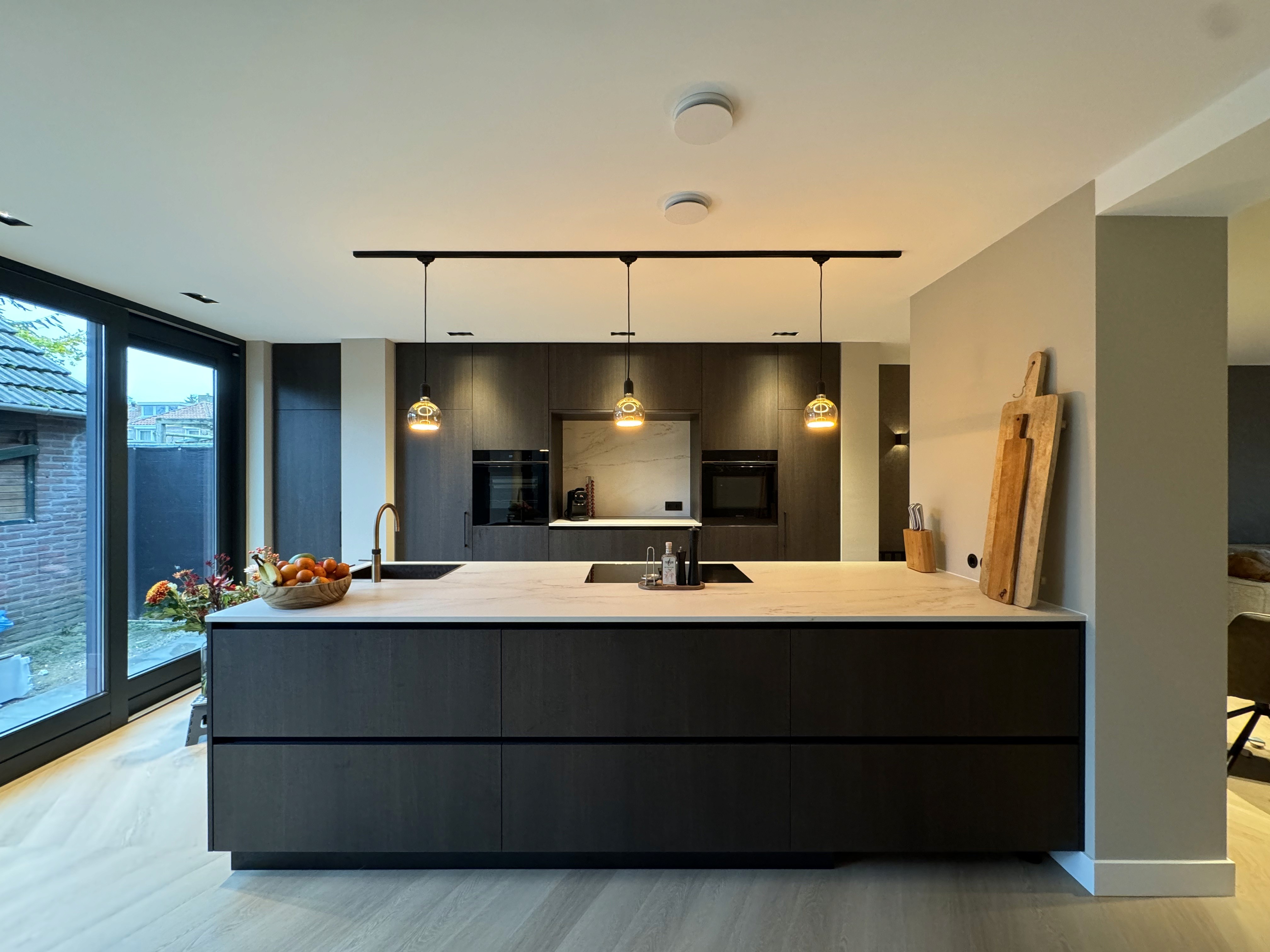 Sfeervolle, moderne keuken in Nuenen met prachtig afgewerkte eilandkeuken, fineerfronten en stijlvol marmeren keukenblad