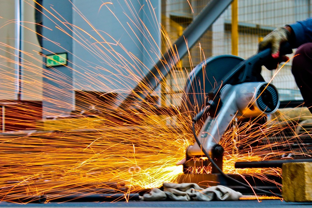 A photo of an industrial engineer cutting metal with a circular saw