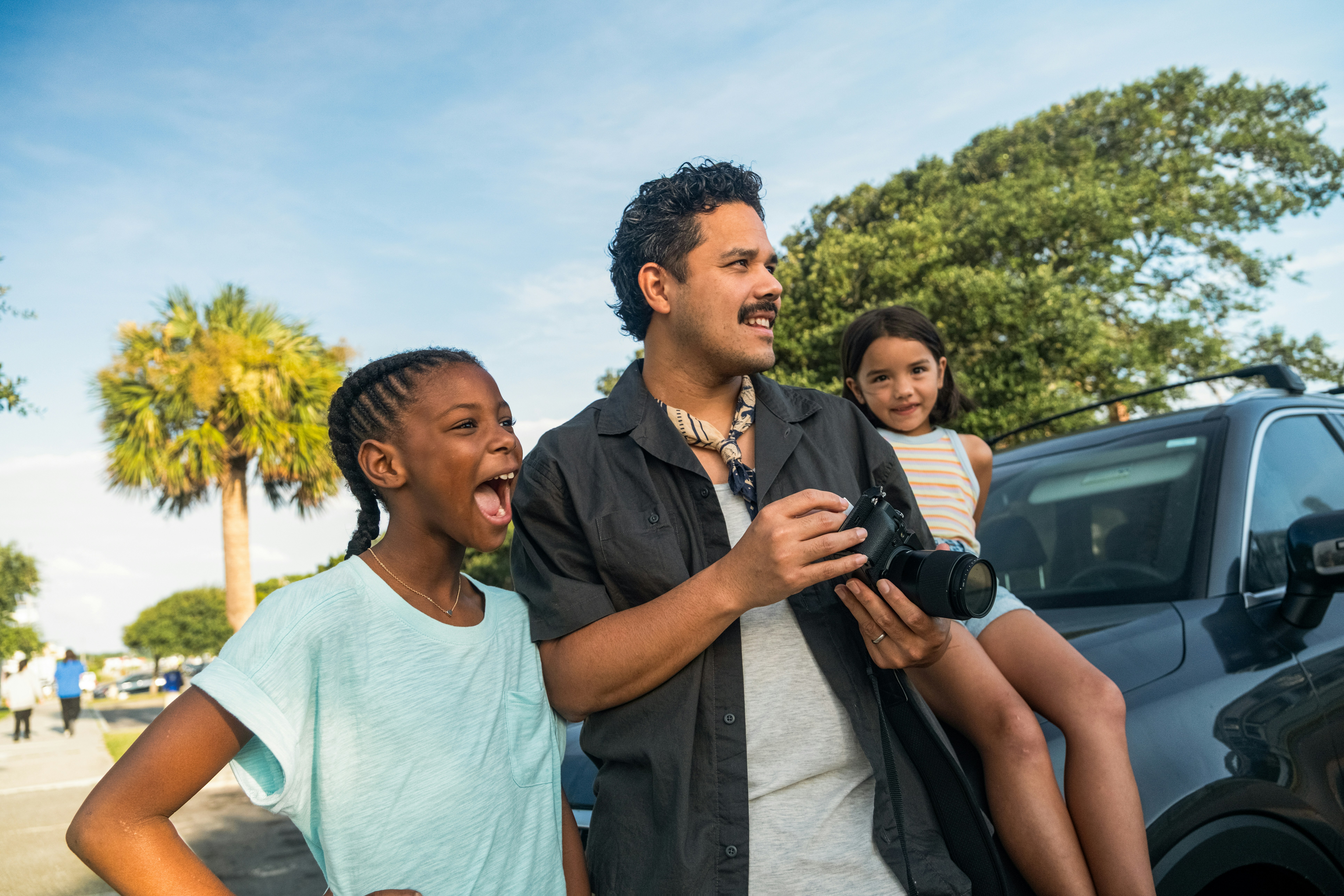 Man with two girls looking away