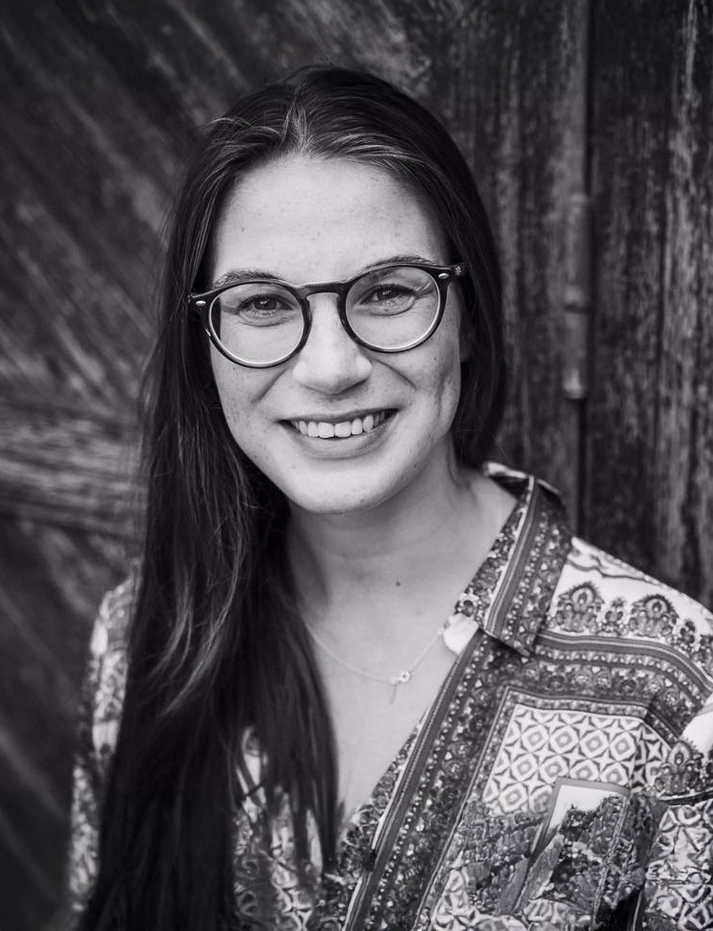 Beautiful women looking in front of a camera hacing long straing hairs with transparent glasses.