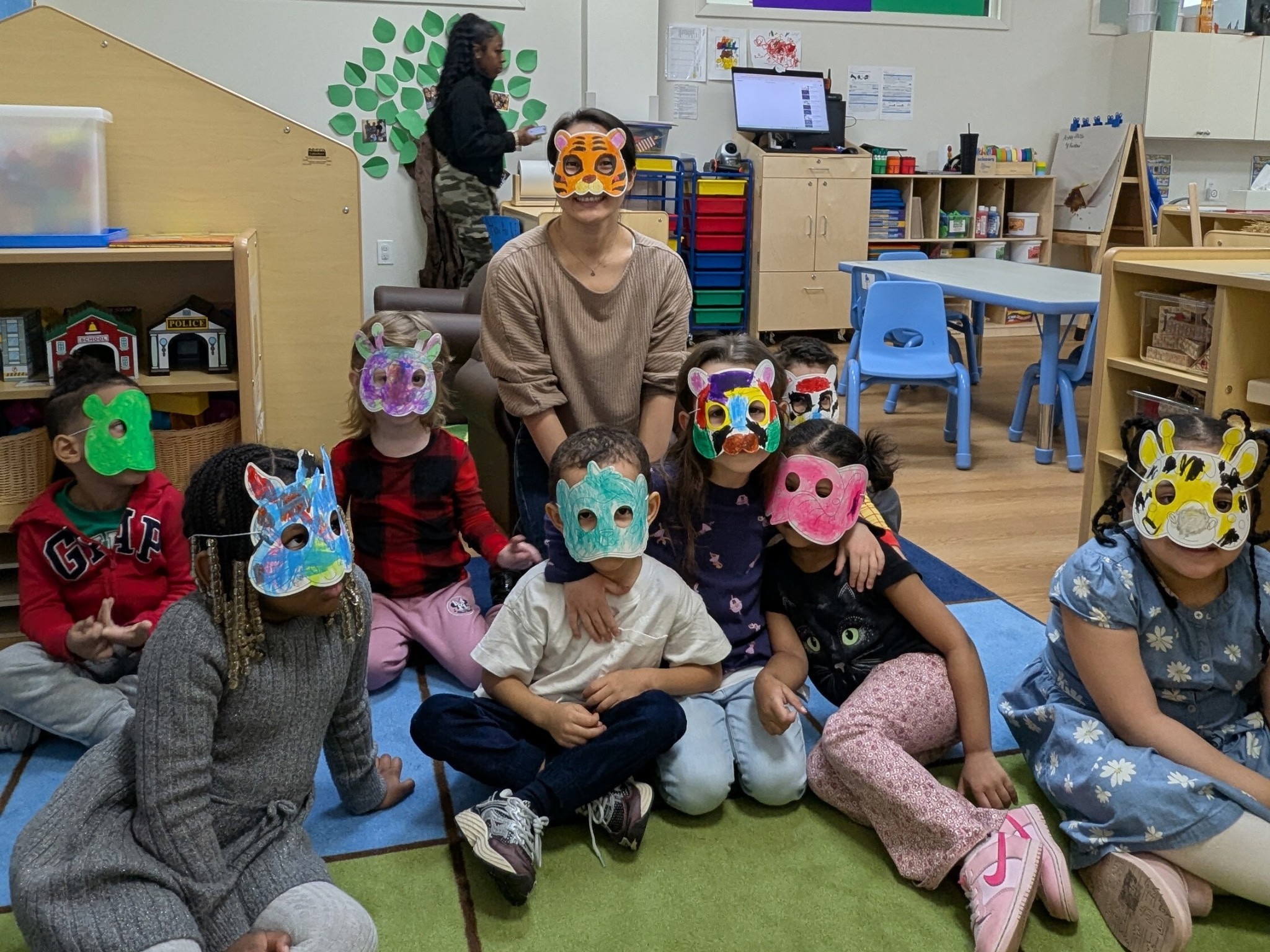 Author Emily Shan and preschoolers wear colorful animal masks.