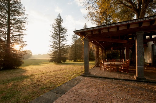 Terraza con árboles de Cobertizo residencia artística al atardecer, Jilotepec, México
