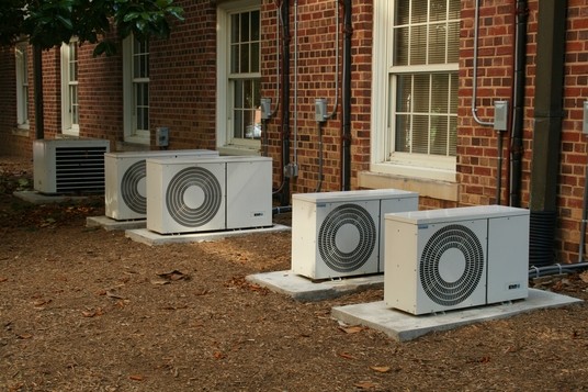 Three heat pumps lying on concrete slabs