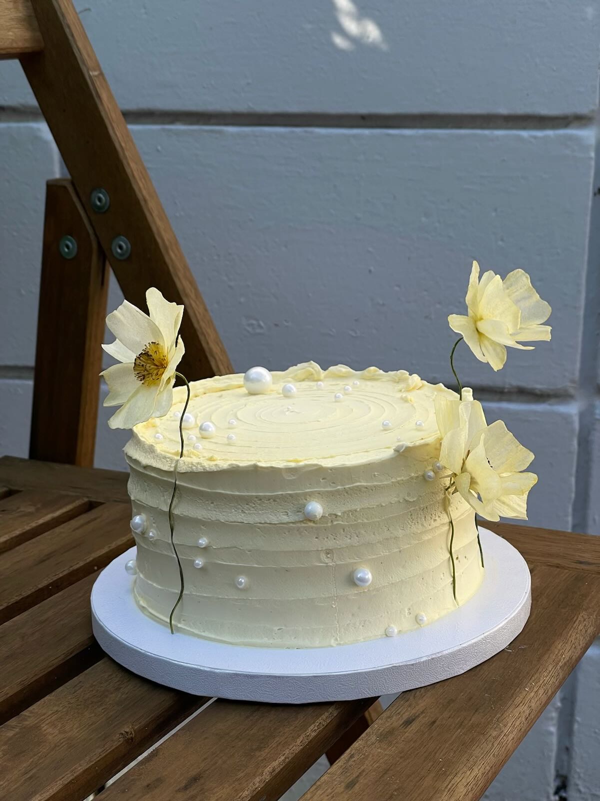 Person with a mustache wearing a black t-shirt carrying a tall stack of pizza boxes inside a dimly lit bar or restaurant.