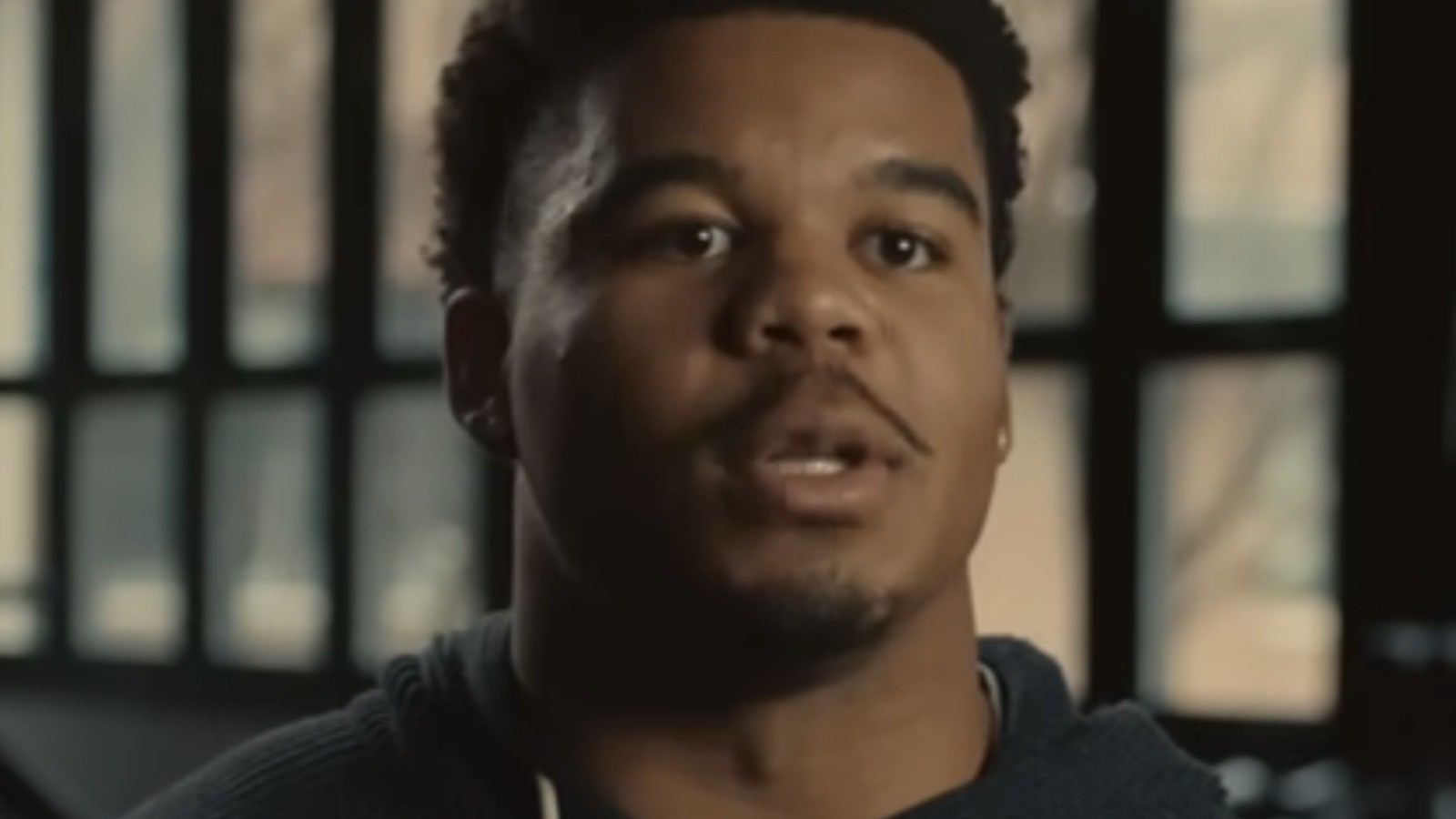 Chop Robinson in a dark hoodie speaking, face centered in a close portrait