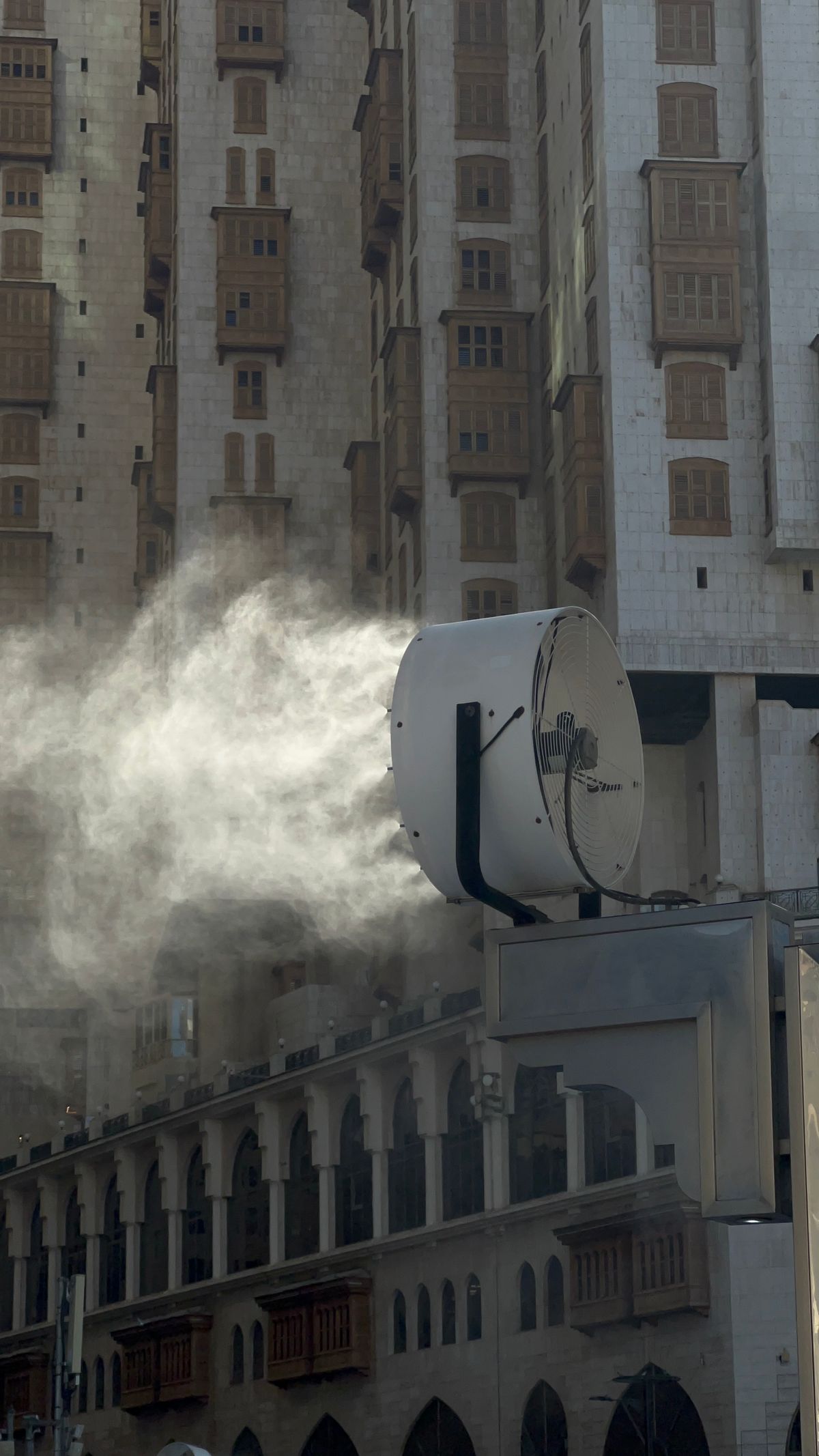 A large misting fan cooling an urban public space during hot weather