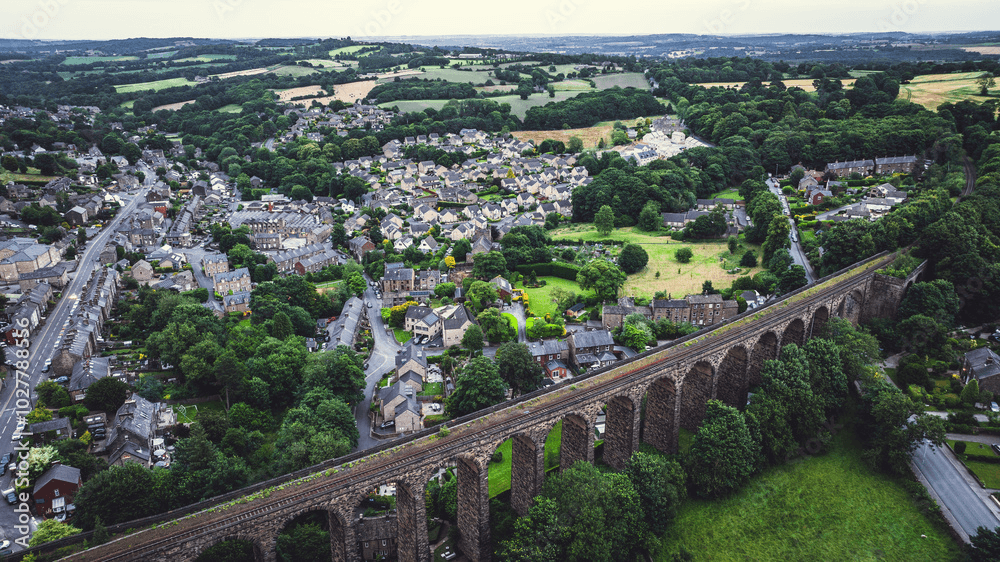 Cityscape with a tall chimney and distant water