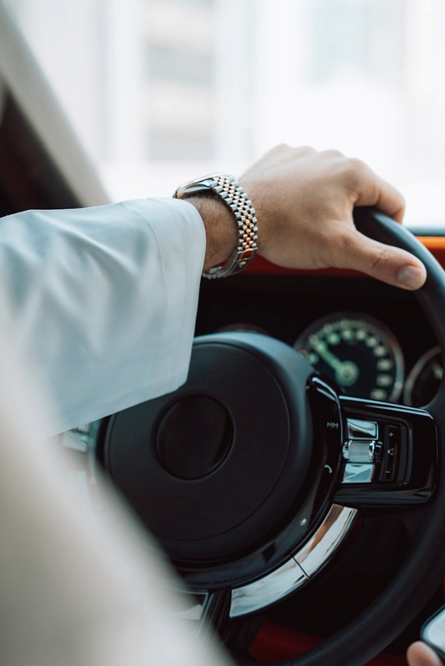 La main d'un homme sur le volant d'un véhicule de luxe